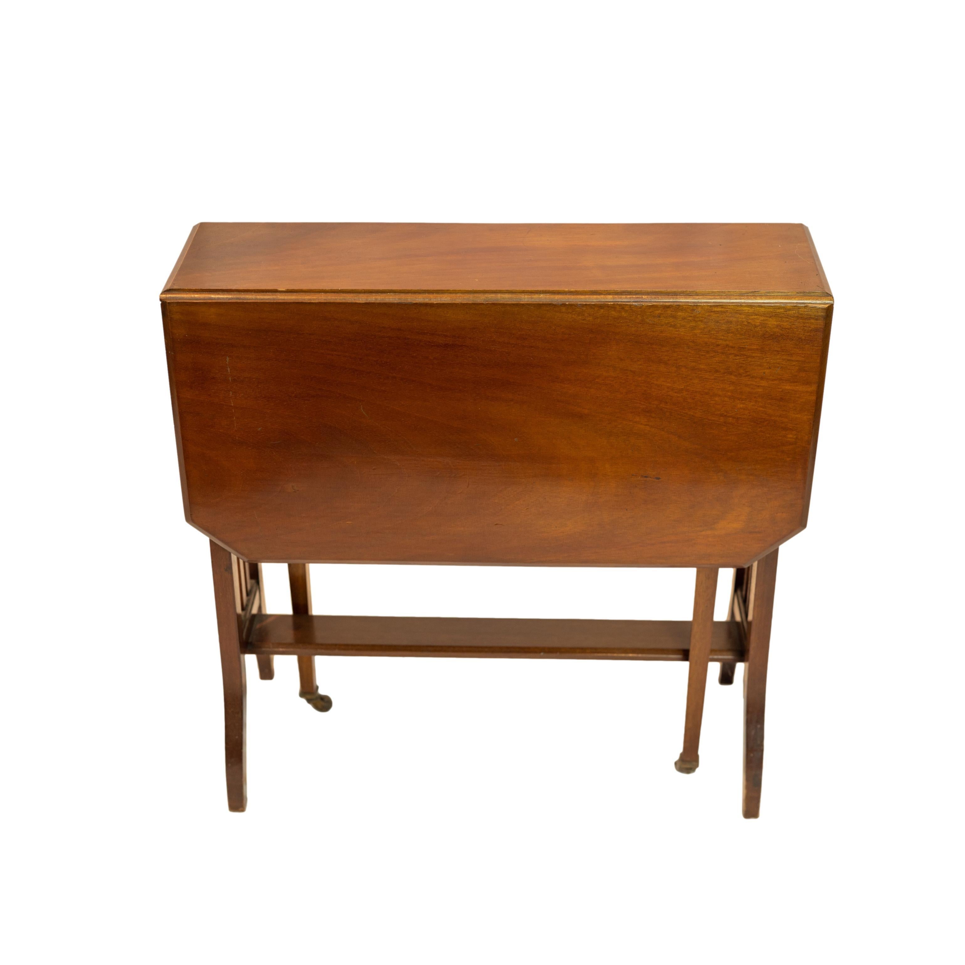 Arts and Crafts drop-leaf Sutherland table, the narrow tabletop in mahogany (slight sun fading), with two canted-form mahogany drop-leaves, on an Arts & Crafts, slated and flared base, with central stretcher bar, and two retractable tapered legs