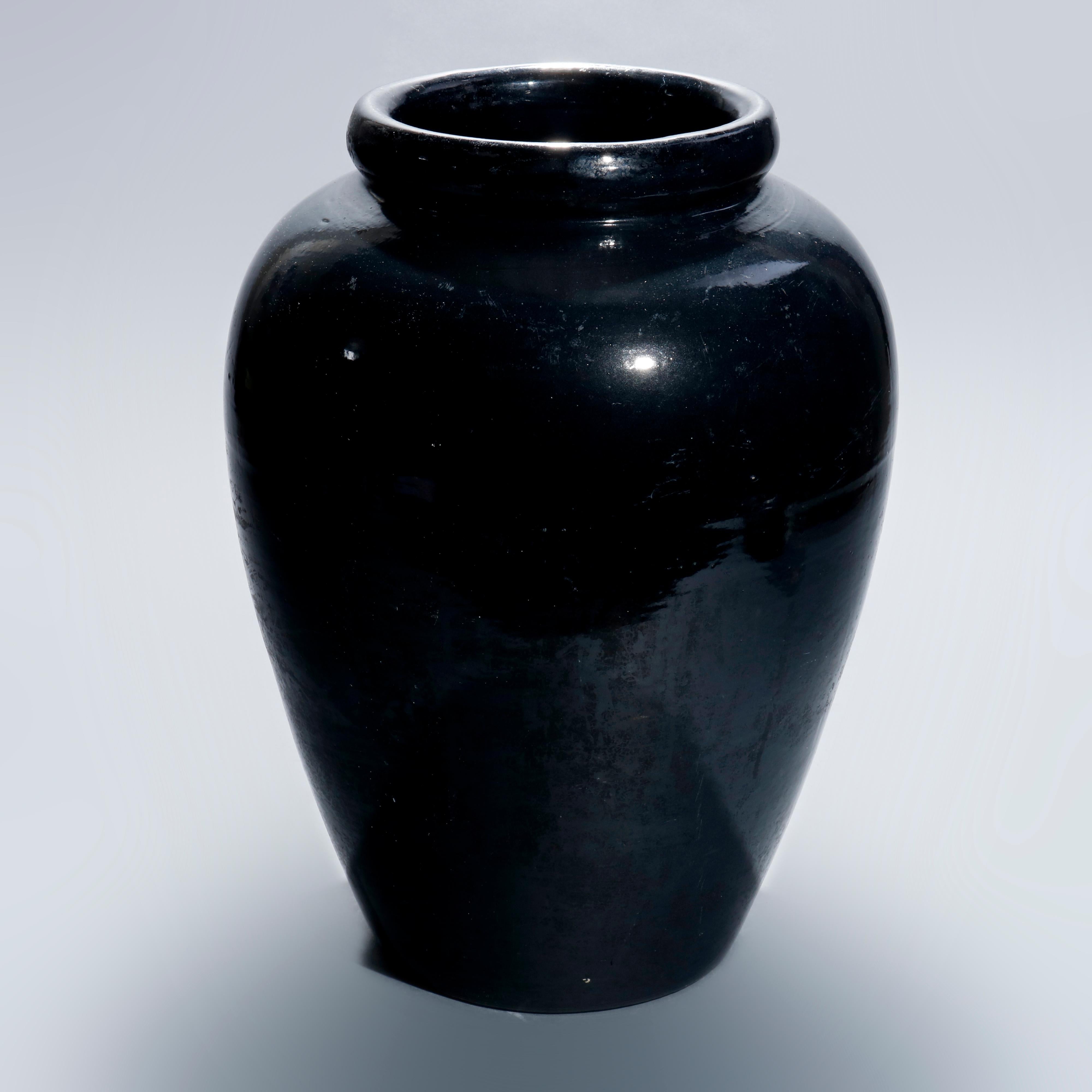 An Arts & Crafts art pottery floor vase in the manner of McCoy offers glazed exterior and hand numbered on base as photographed, 20th century

Measures: 18