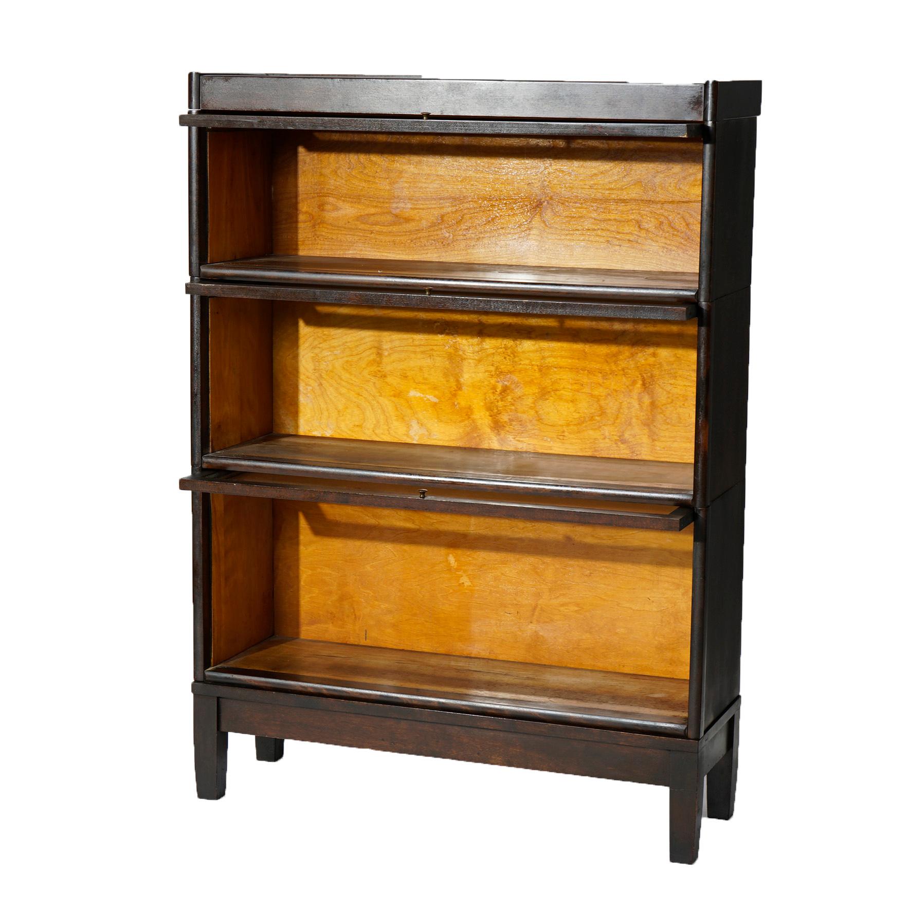 An antique Arts and Crafts Mission barrister bookcase in the manner of Globe Wernicke offers mahogany construction with three stacks, each having pull out glass shelves, raised on square and straight legs, c1910

Measures- 47.25''H x 34.25''W x