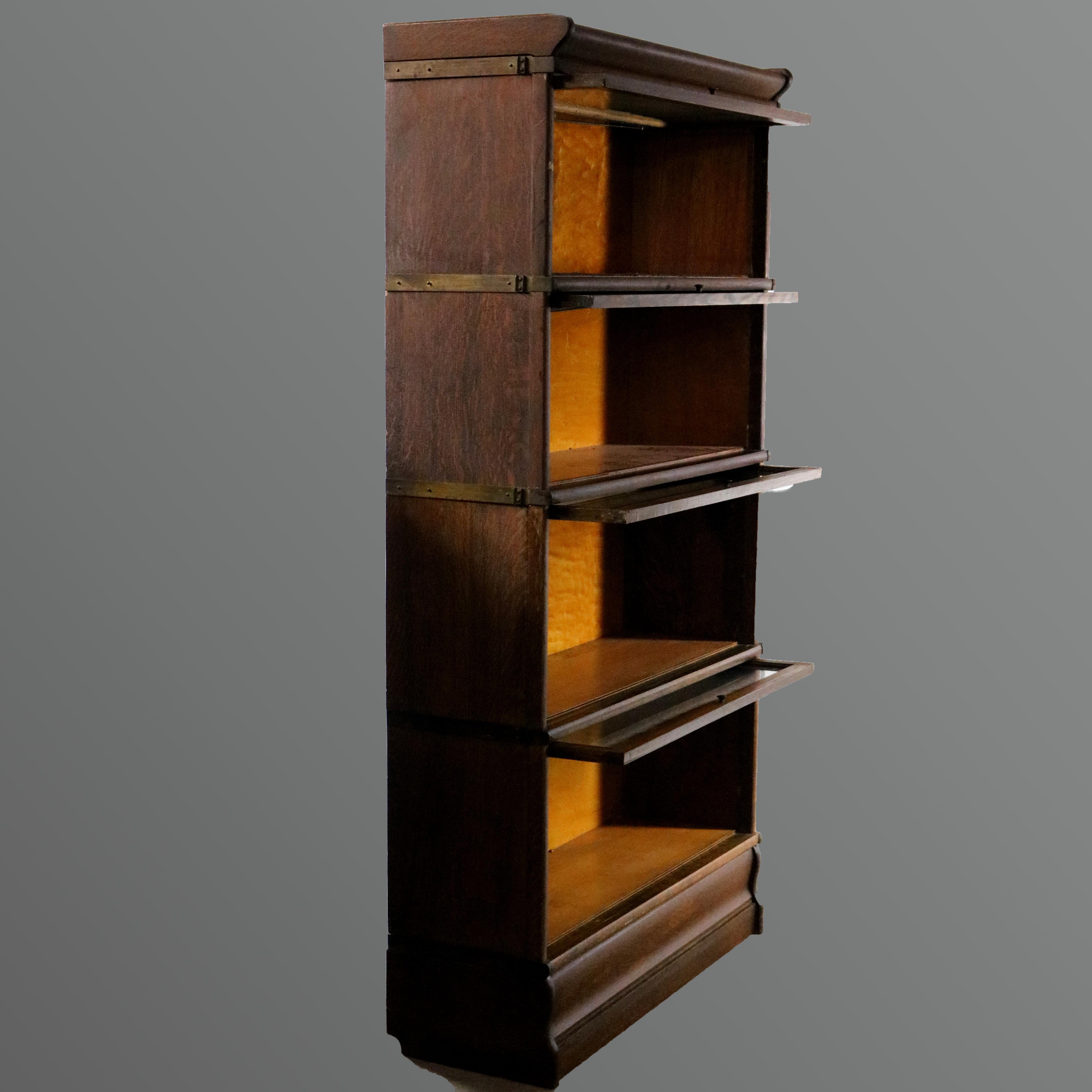 An Arts & Crafts sectional Barrister bookcase by Hale's, Herkimer, NY, offers quarter sawn oak construction with four stacks having a pull-down glass door on shaped base surmounted by removable crown, circa 1920

Measures- 63.25