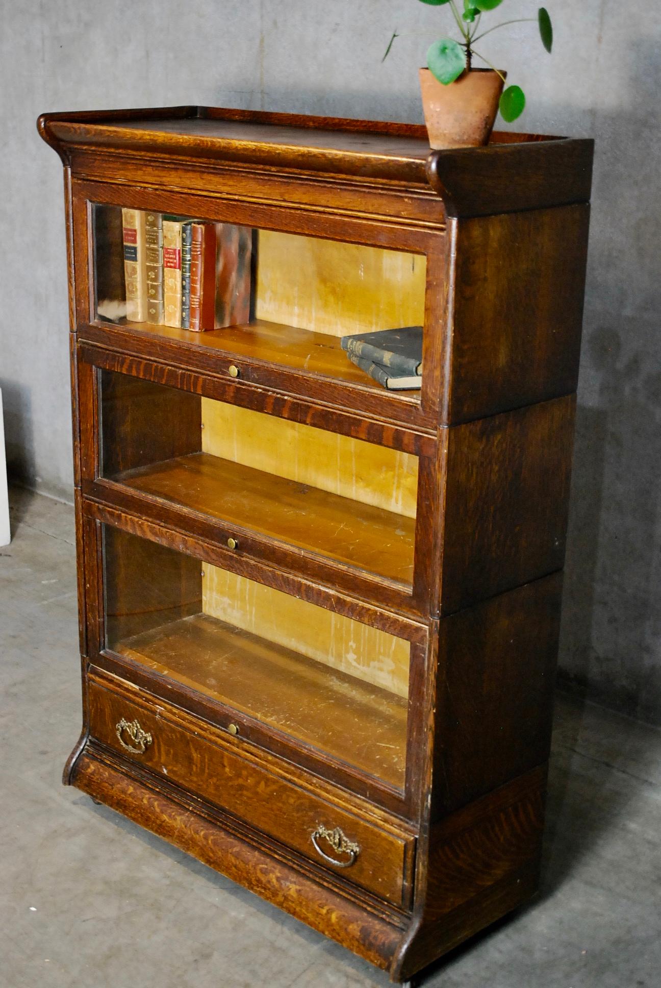 An antique Arts & Crafts Mission Barrister stacking bookcase by Grand Rapids Michigan Co. , offers quarter sawn oak construction with three sections having pull-out glass doors, drawer, original labels as photographed, circa 1910 .
Features
