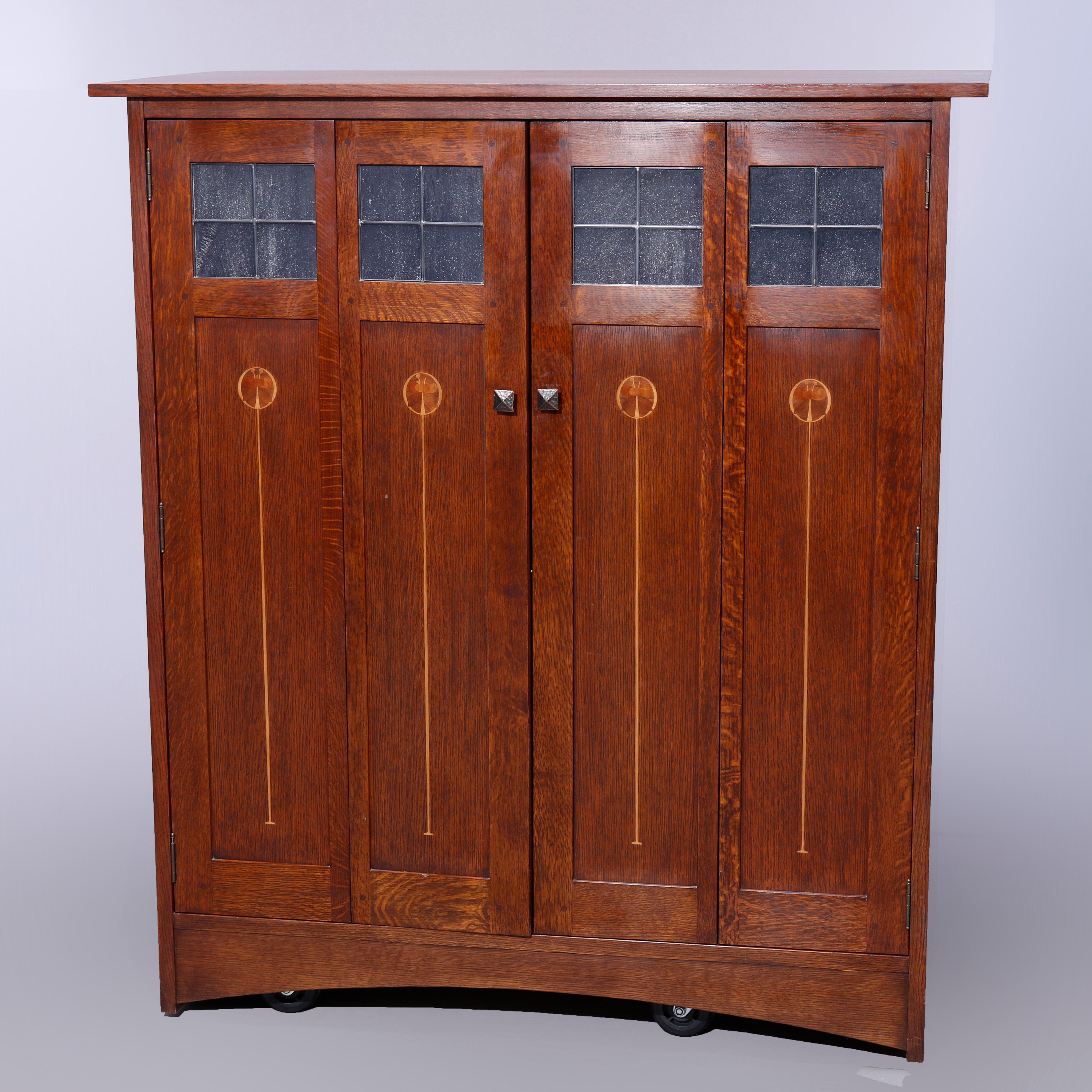 An Arts and Crafts Mission Oak entertainment center by Stickley offers Harvey Ellis Design with double doors having stylized marquetry floral inlay20th century

Measures - 57''H x 51''W x 25.25''D.
