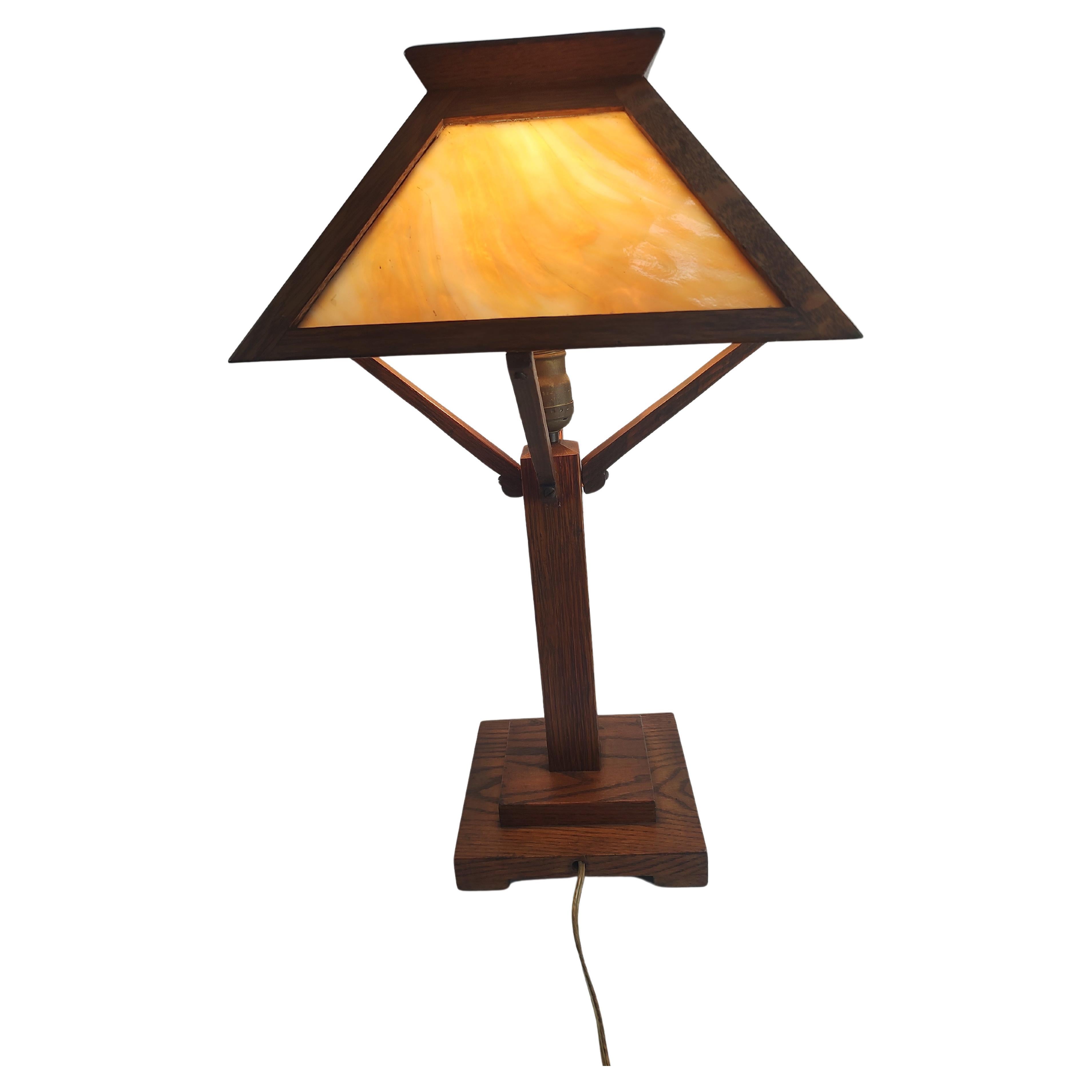Fantastic simple & elegant arts and crafts mission Oak desk table lamp. Beautiful Carmel Colored Slag Glass in a quarter sawn oak lamp frame. Perfectly proportioned and in excellent antique condition with sound wiring. 