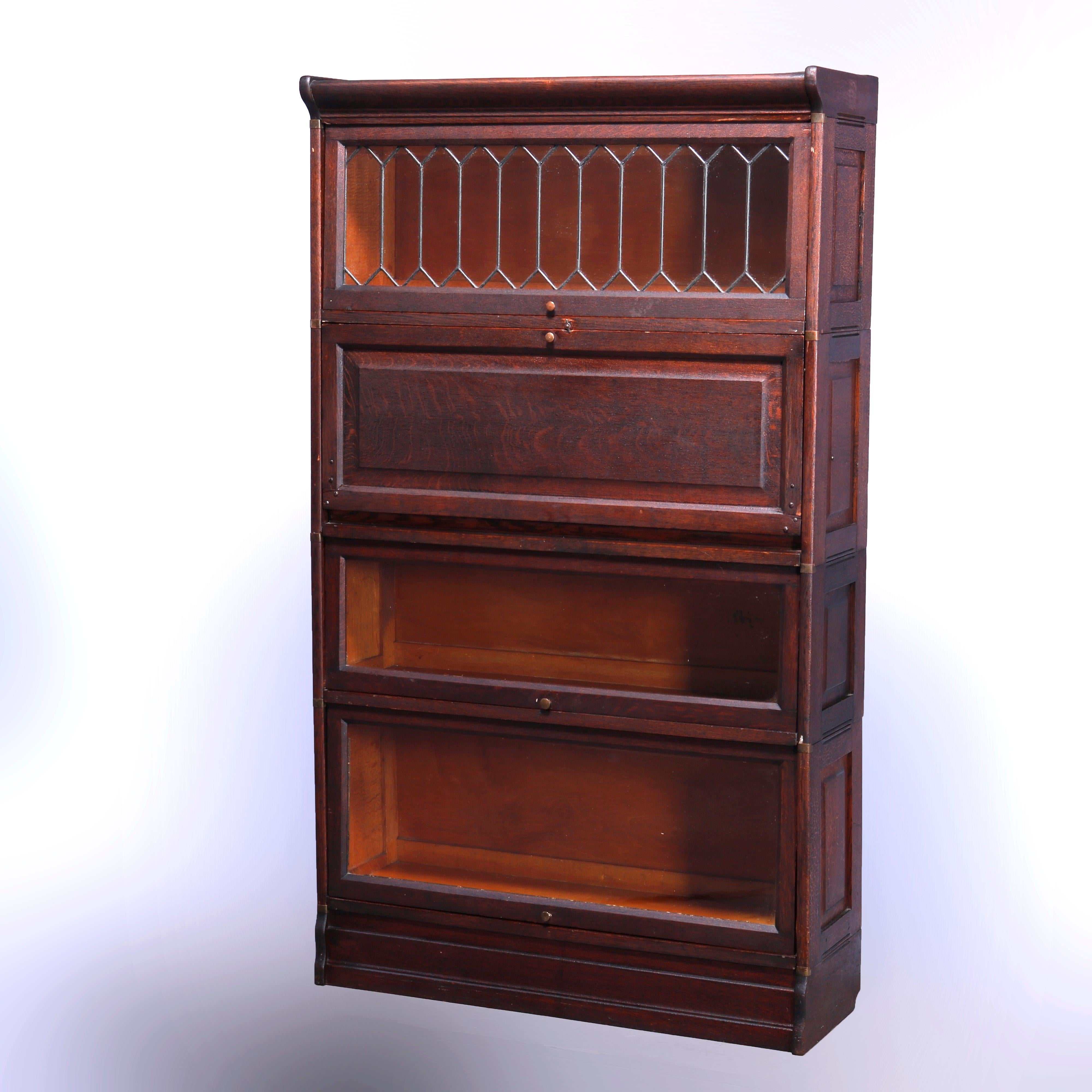 An antique Arts & Crafts mission barrister bookcase secretary offers quarter sawn oak paneled construction with upper having leaded glass door over drop down desk surmounting two glass door bookcase stacks raised on ogee base, c1910

Measures -