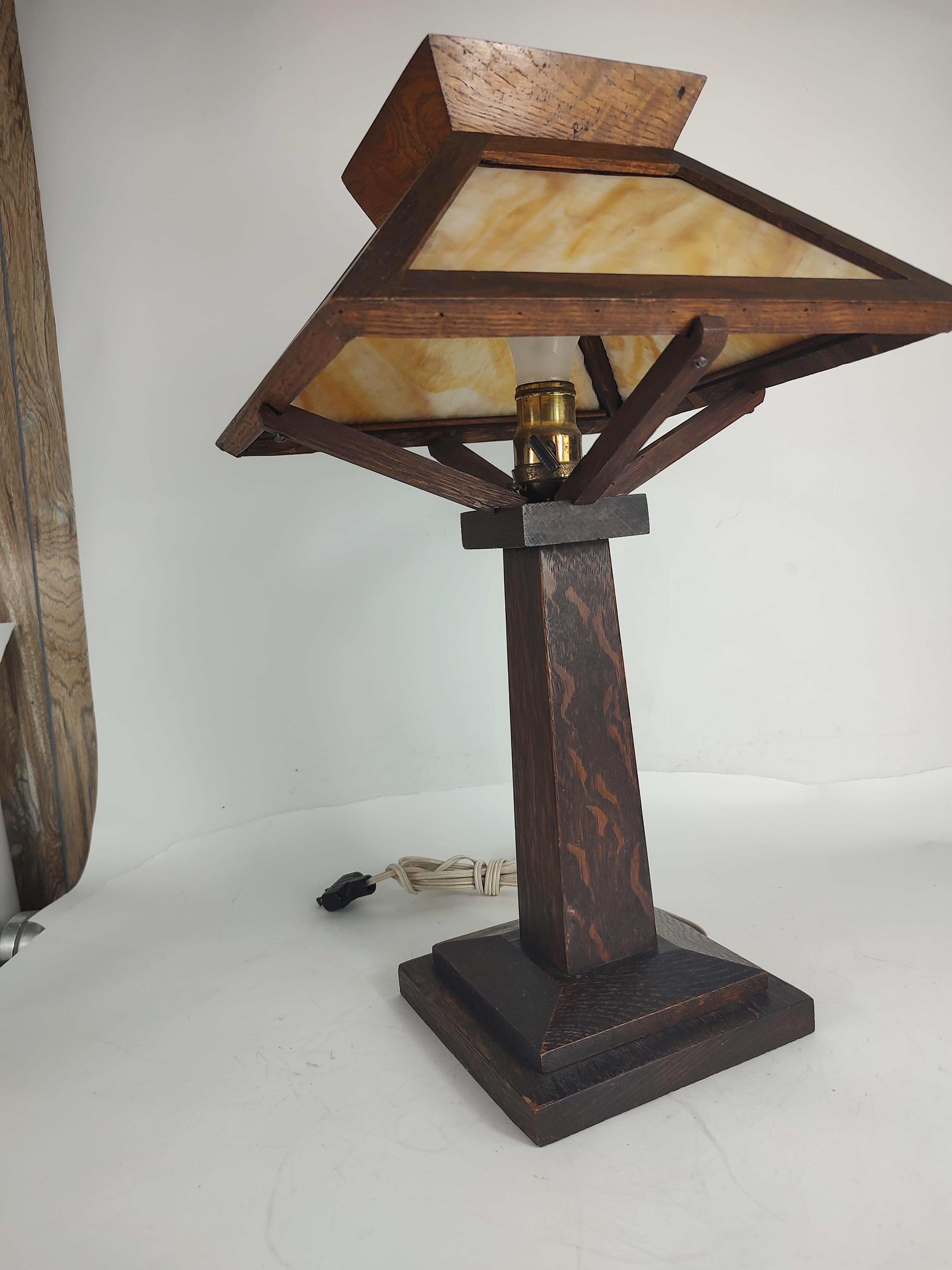 Simple and elegant arts & crafts beige cream colored slag glass table lamp. Quarter sawn oak with a deep stain that shows the grain well. Appears to be totally original and it's in excellent antique condition with minimal wear. Wiring and socket are
