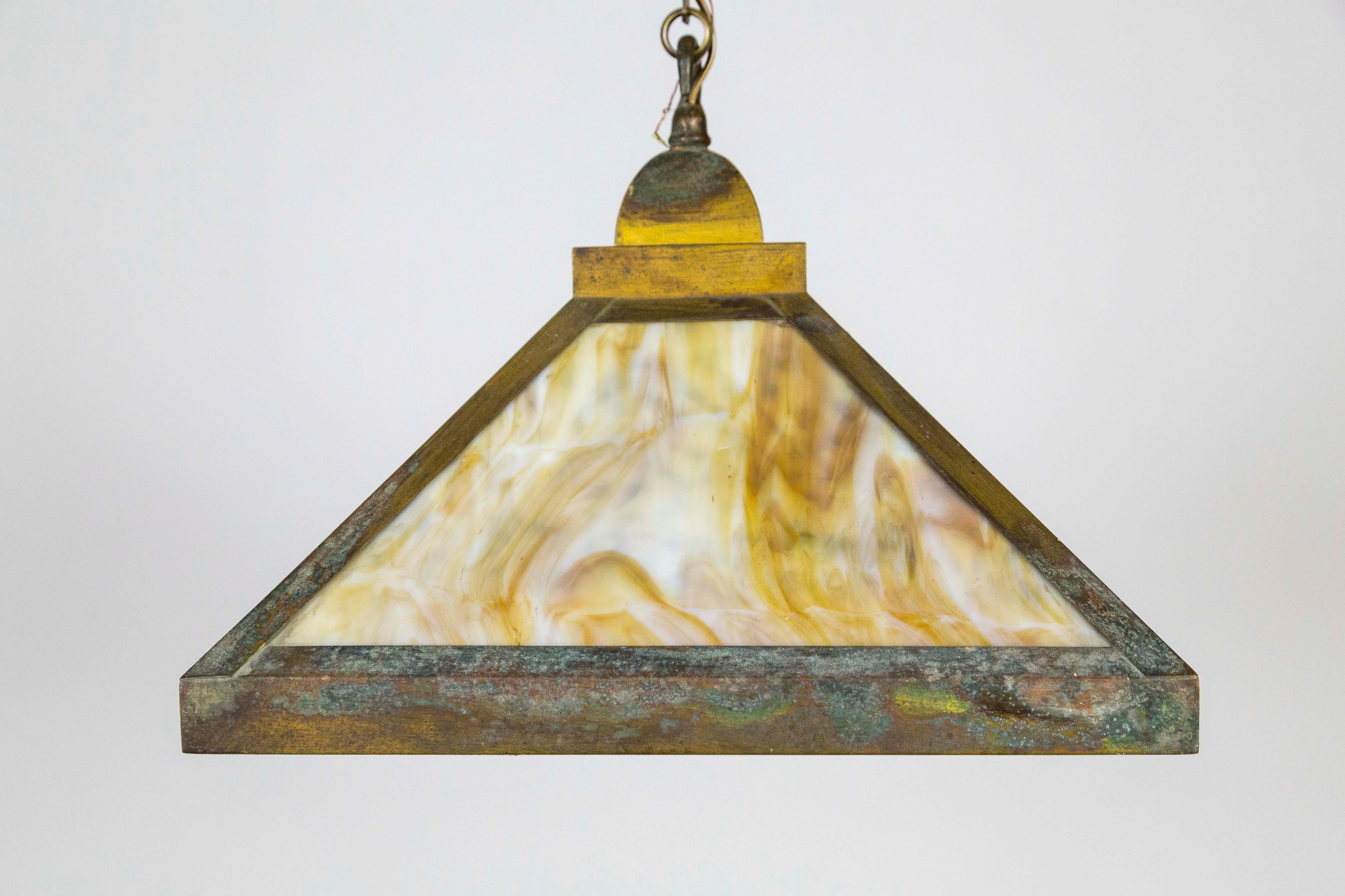 An original, early 20th century, Arts & Crafts pendant light composed of amber and white swirl stained glass panels in a 4-sided pyramid shape; the brass structure has a gorgeous patina and unique chain. 3 lights, newly wired. Measures: 16