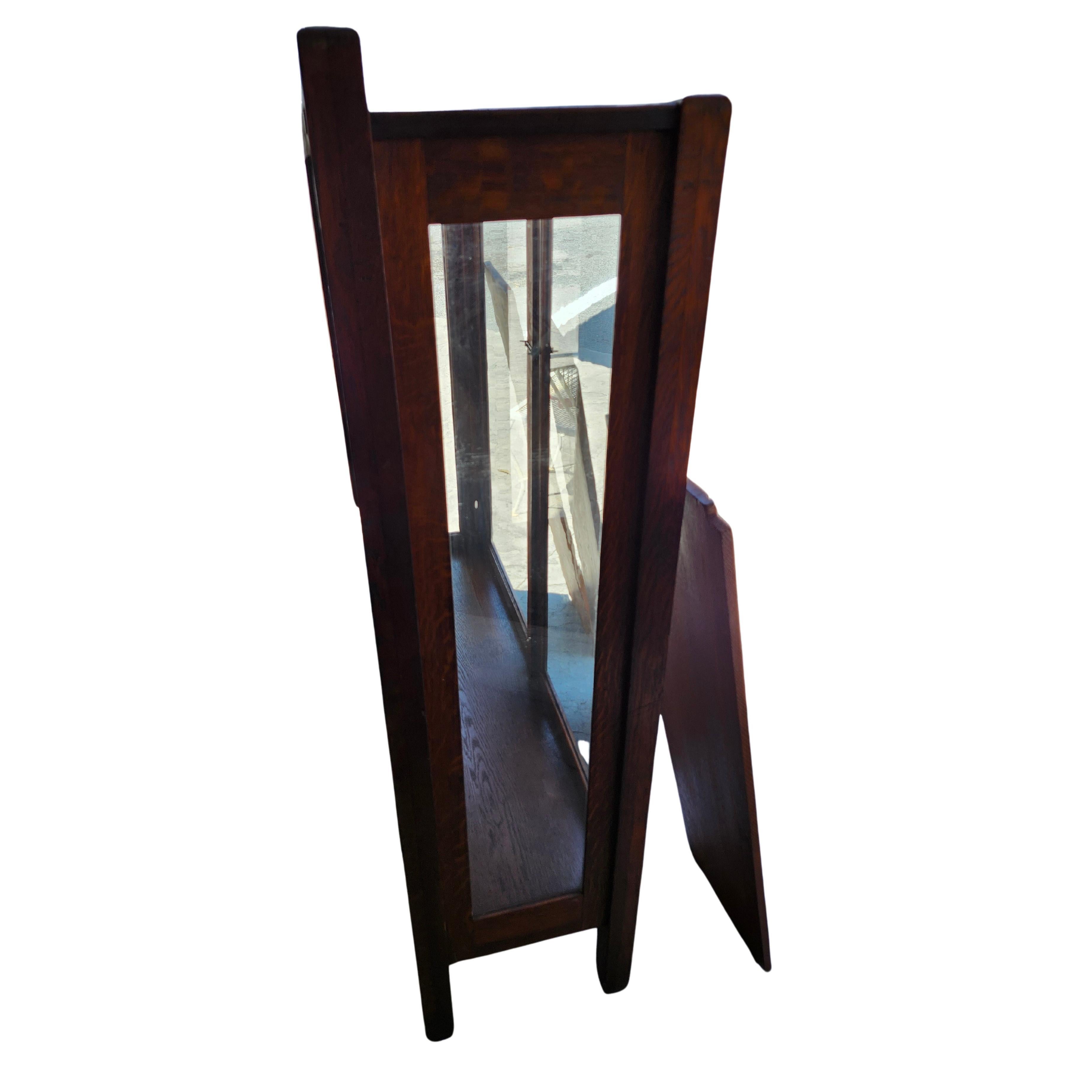 Fabulous two door display china/bookcase cabinet with 3 full length shelves. Created around 1910 out of quarter sawn oak with hand hammered hinges and hardware. A mirror is on the top back for displaying your wares. Simple yet elegant, this cabinet