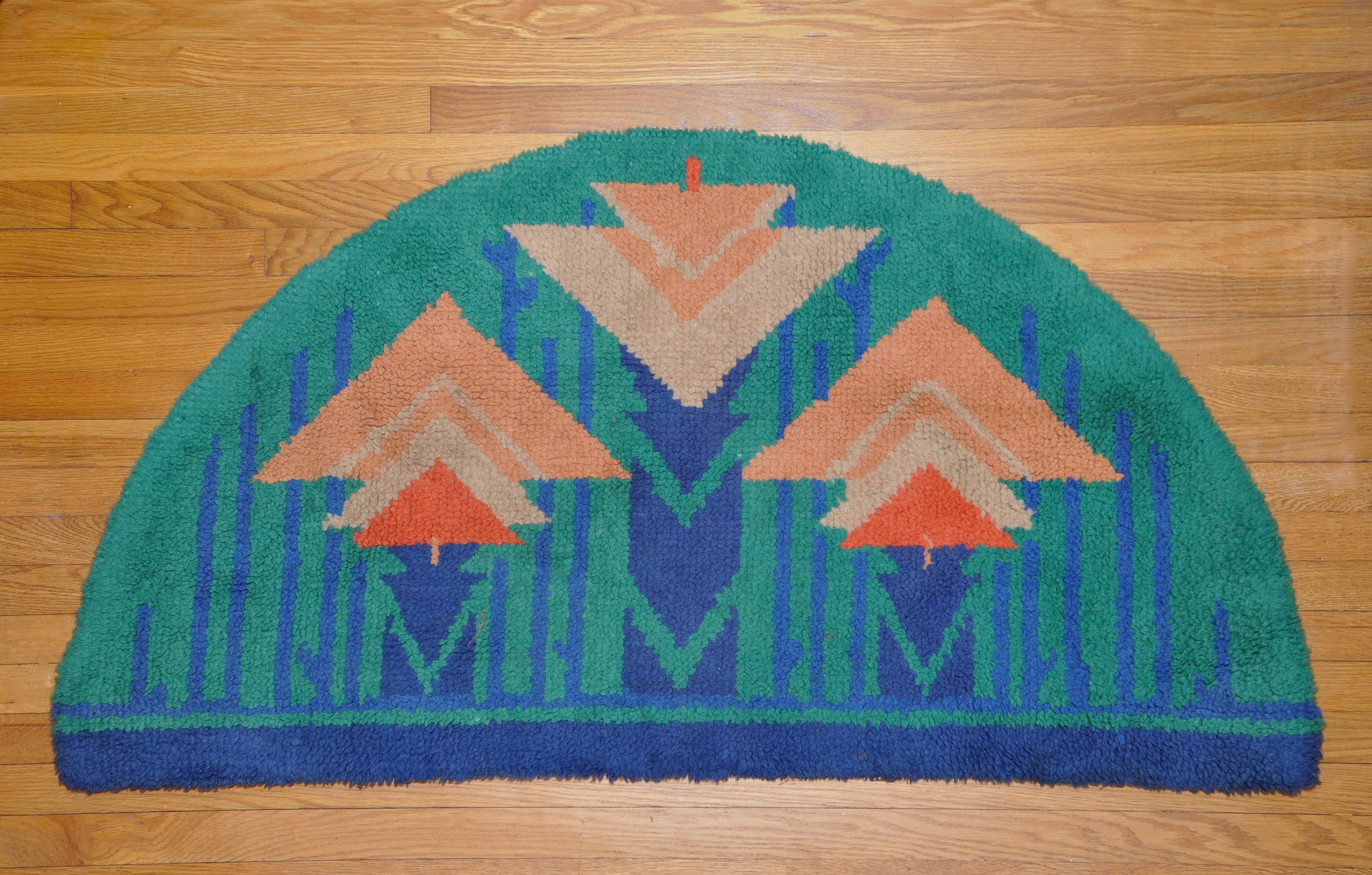Arts & Crafts (Craftsman) hand-tufted semi-circular hearth rug in a geometric style with a leading motif of superimposed triangles. Thick and luxurious. Strong, bold colors. Probably European, possibly Scandinavian. Could be displayed as a wall