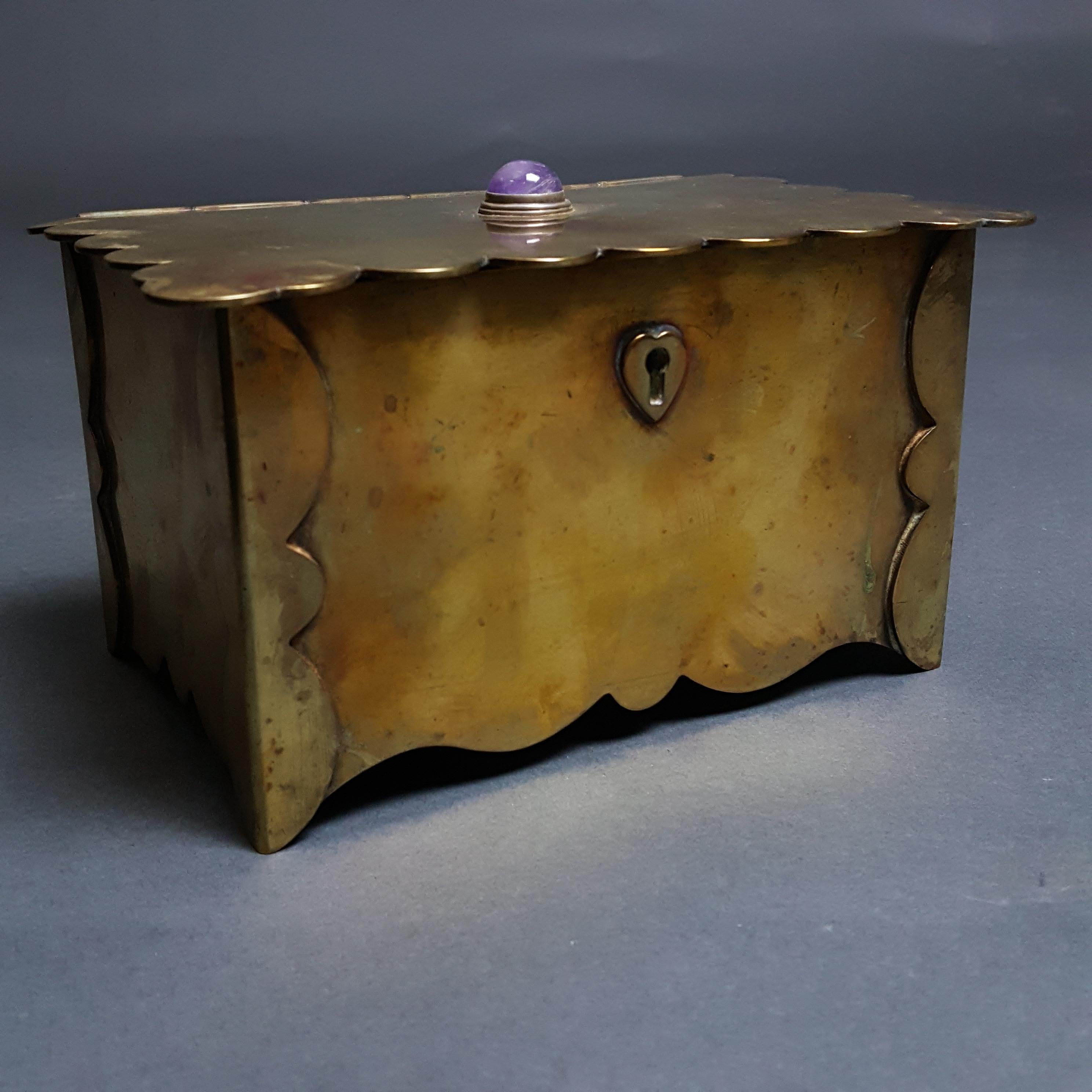 Caja artesanal de latón del Movimiento Arts & Crafts de buena calidad con cabujón de amatista que data de alrededor de 1900. Si quieres más imágenes, envíanos un correo electrónico.