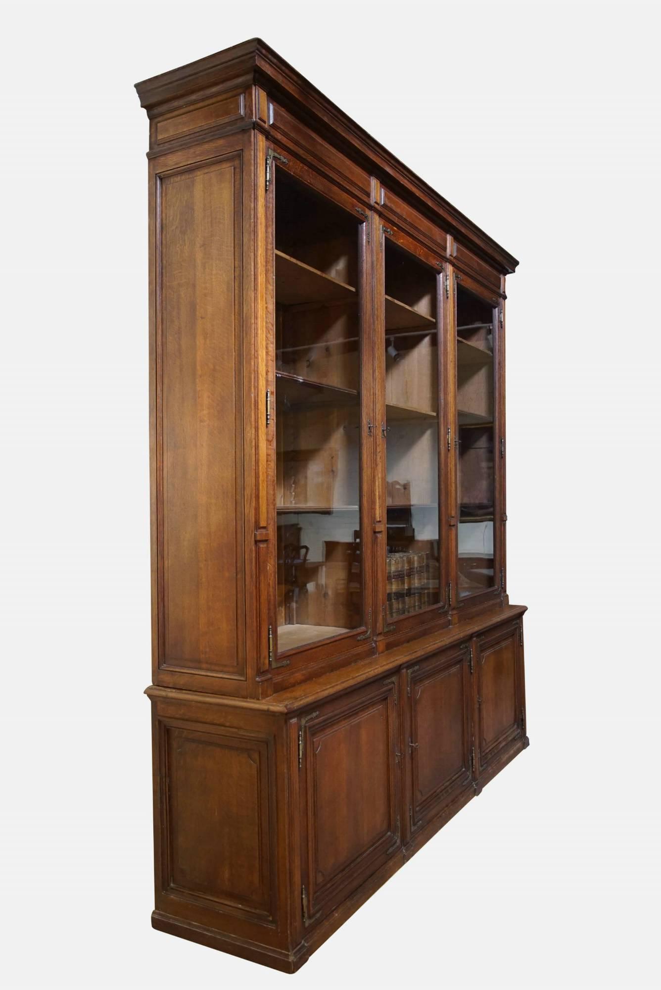 An imposing Arts & Crafts, brass mounted oak bookcase.

 Comprising three doors with brass corners to the top and three doors with en suited corners to the base,

circa 1880.