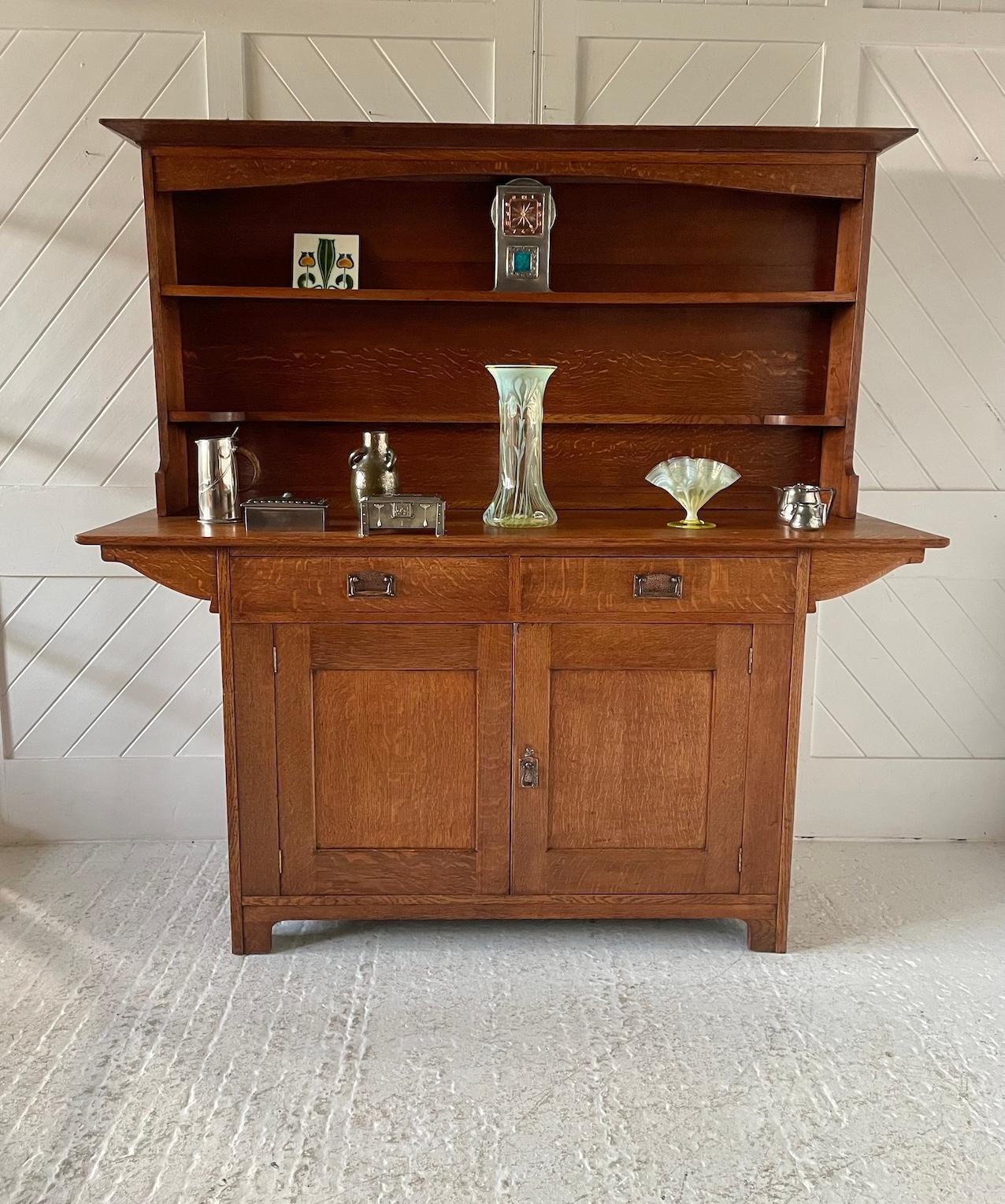 Commode en chêne Arts & Crafts Cottage

Avec 2 étagères encastrées, 2 tiroirs coulissants et 2 portes de placard

Poignées en cuivre battu

Circa 1905

Liberty & Co

Hauteur 173 cm. Largeur 171cm. Profondeur 55cm

Illustré dans Liberty Furniture Par