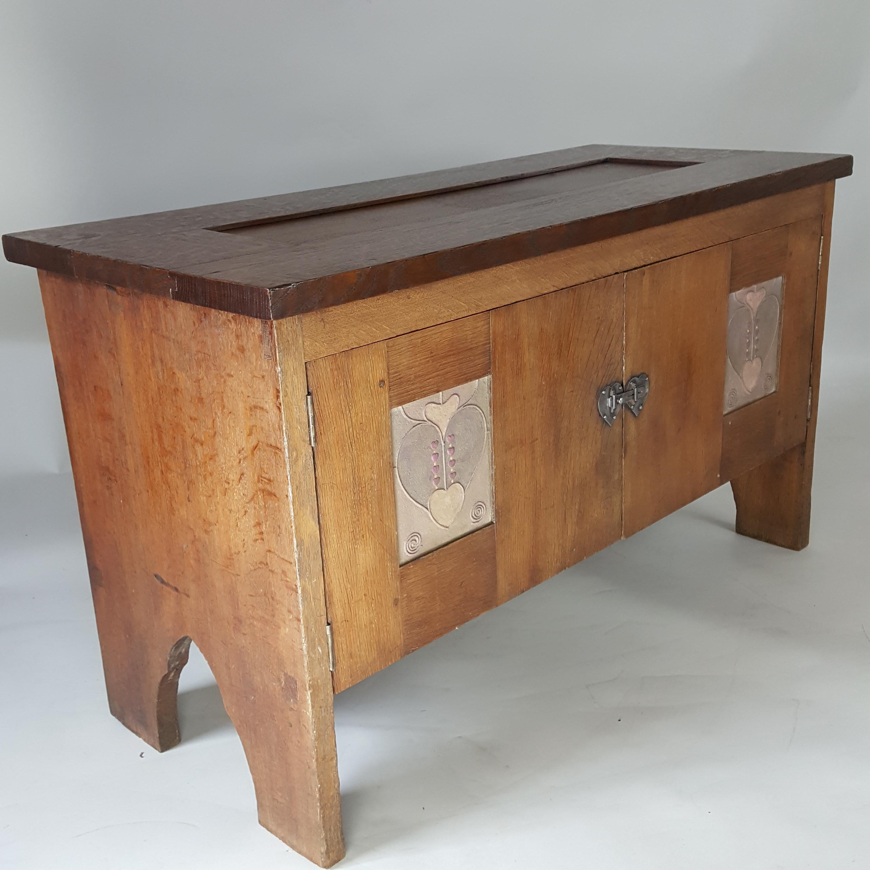 Rare armoire basse ou coffre en chêne Arts & Crafts à 2 portes avec panneaux en gesso et loquet en acier en forme de cœur attribué au designer écossais Henry T Wyse.  Circa 1900