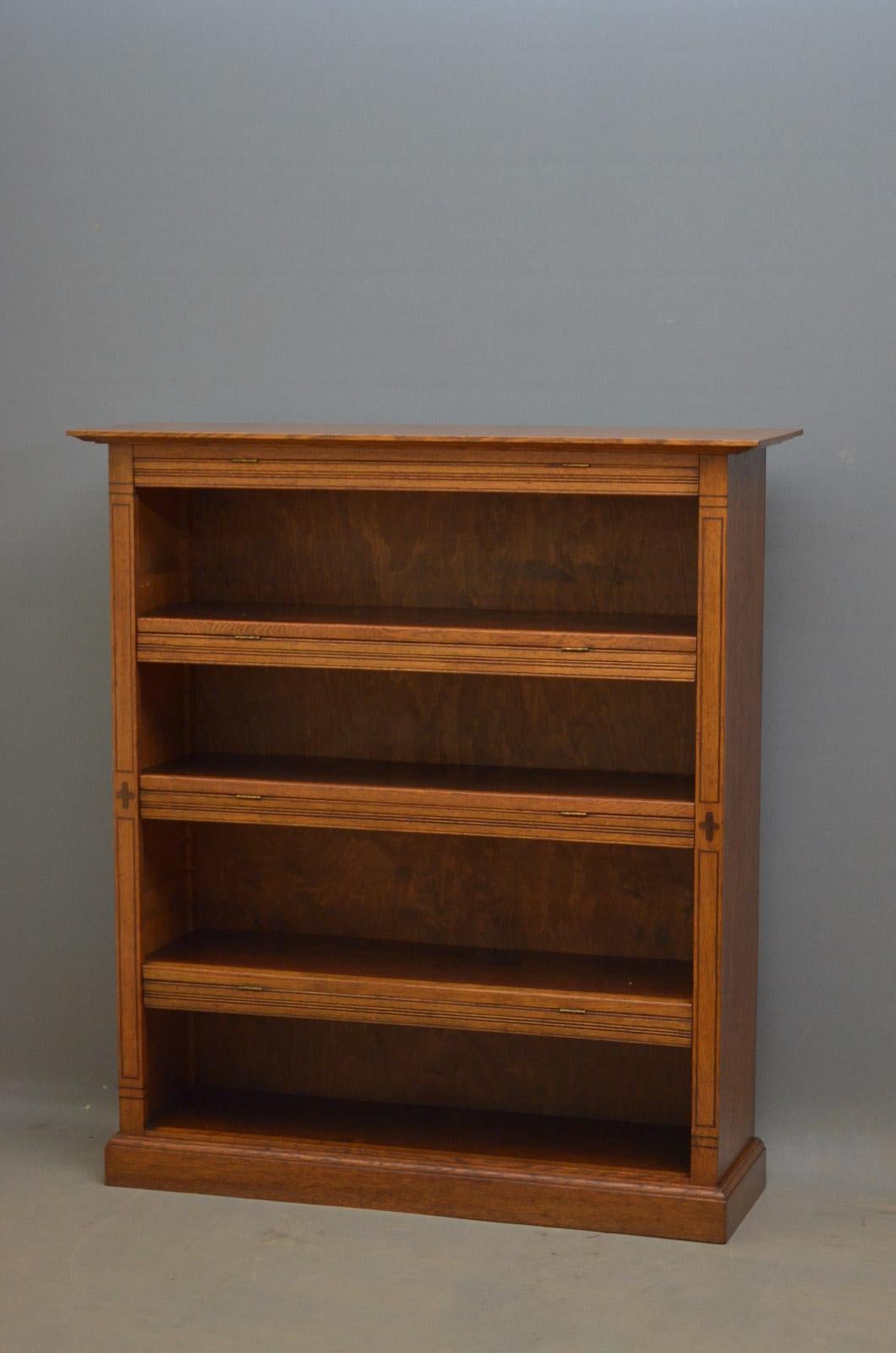 R00 Arts & Crafts oak bookcase, having over-sailing top above 3 height adjustable shelves fitted with hinged dust covers and flanked by string inlaid pilasters, standing on moulded plinth base. This antique bookcase is in excellent original