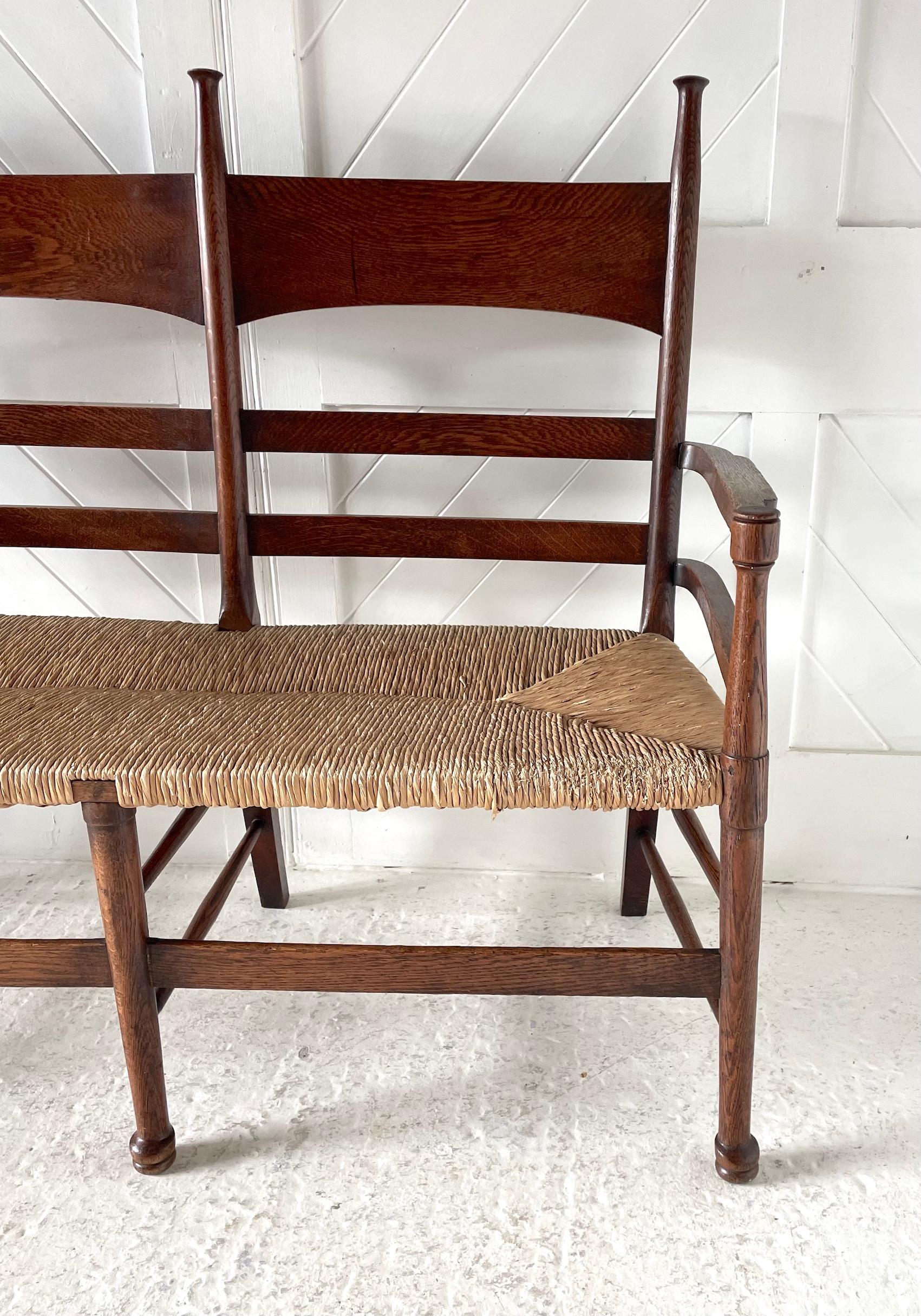 Sedia a 2 posti Arts & Crafts 

In Oak con sedute in giunco 

Di William Birch.   

CIrca 1900 

Altezza 110 cm.  Larghezza 128 cm.  Profondità 57 cm.  Altezza della seduta 47 cm 