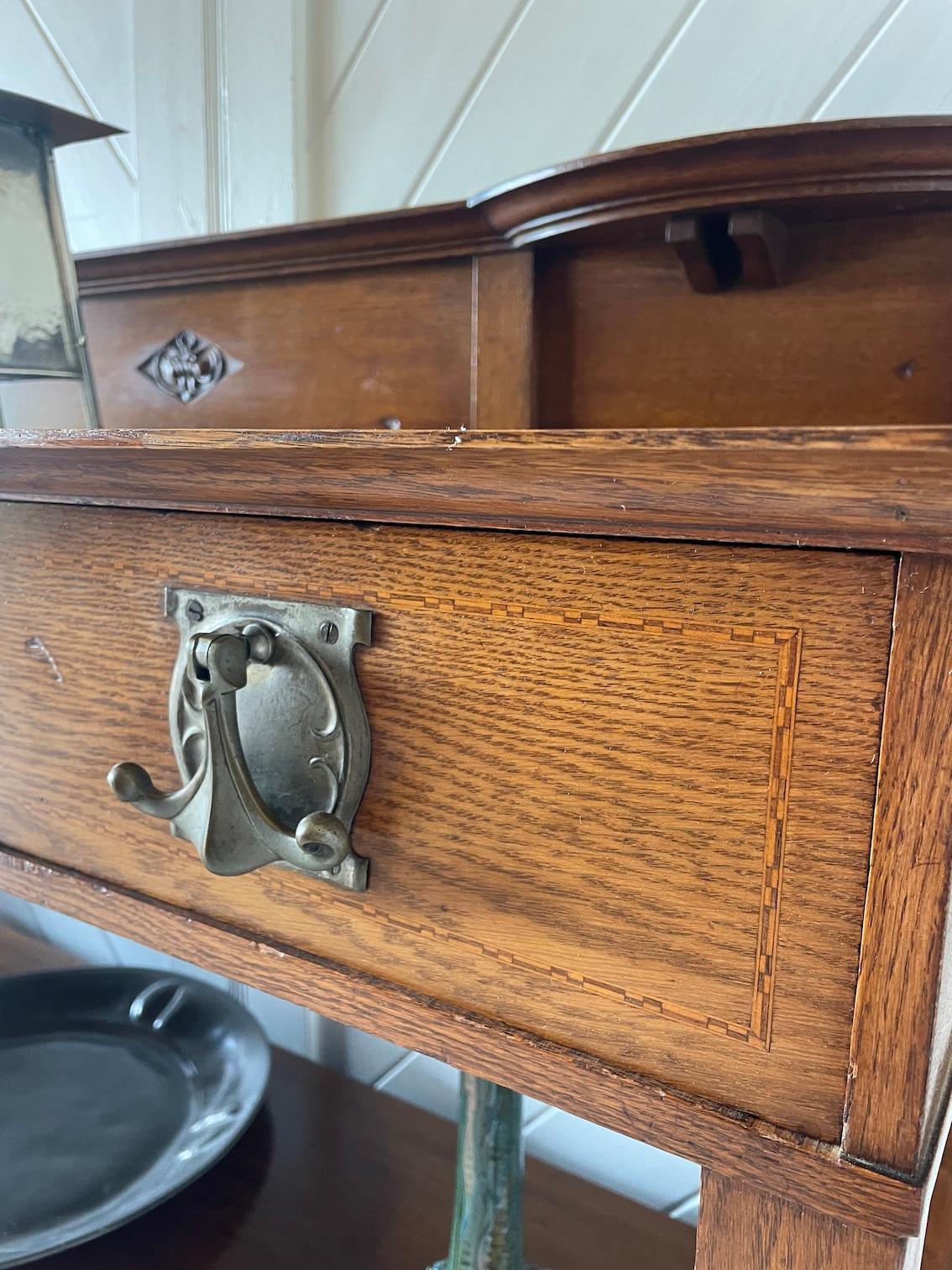 Buffet en chêne Arts & Crafts avec 4 armoires

Tiroir central incurvé avec 2 tiroirs de chaque côté

Motif sculpté et incrustation de bandes en damier

Poignées en laiton nickelé

Circa 1900