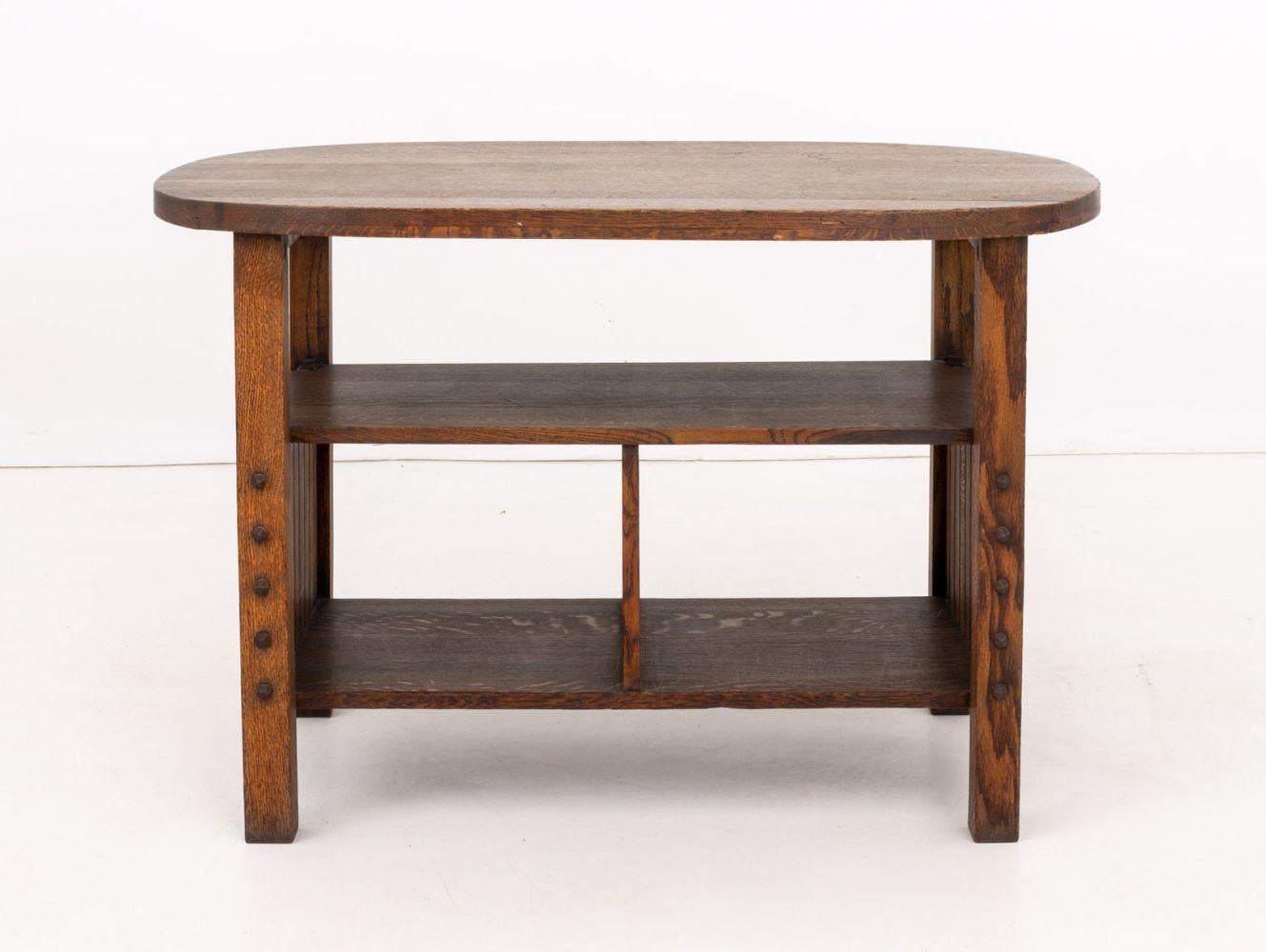 Table d'appoint ovale à deux niveaux en chêne Arts and Crafts, début du 20e siècle, avec deux armoires au-dessus des roulettes. 28.75