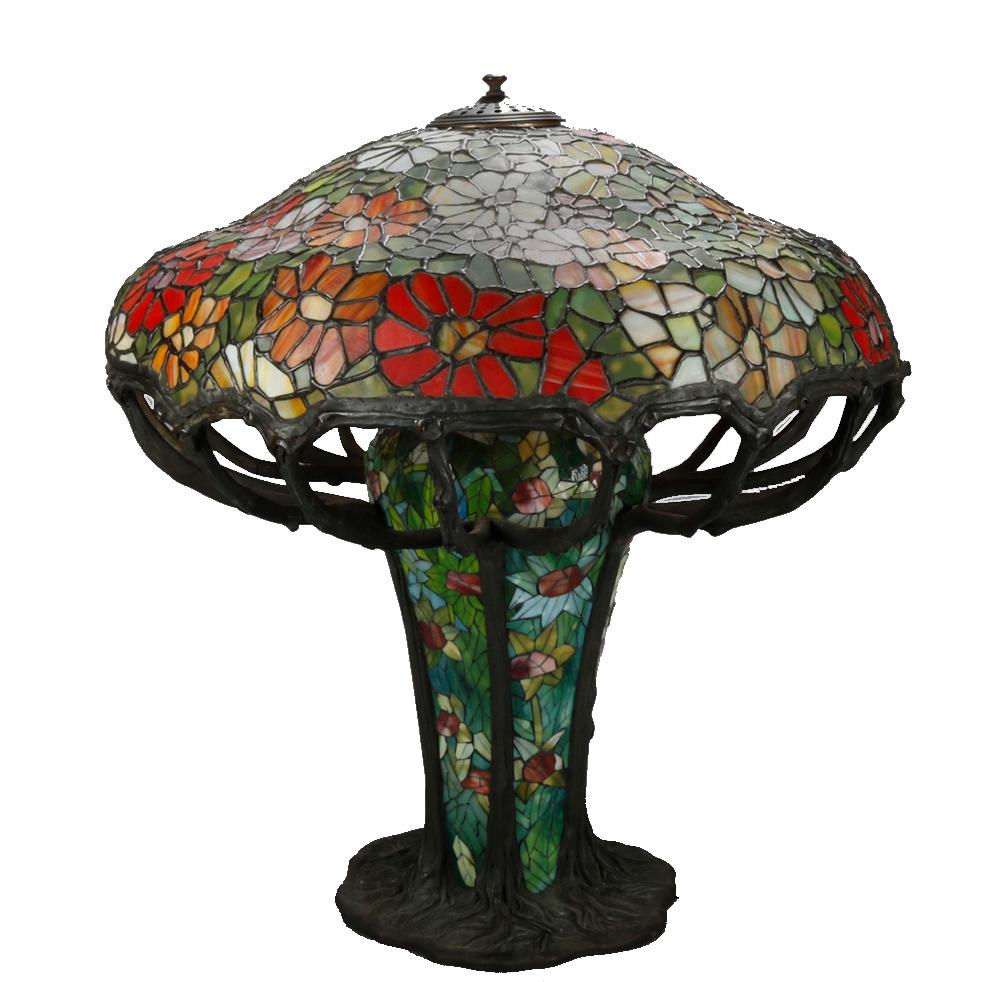 An oversized antique Arts & Crafts (into Art Nouveau) table lamp in the manner of Tiffany Studios offers floral mosaic leaded slag glass shade and base with branch form supports and three sockets, 20th century

Measures: 27