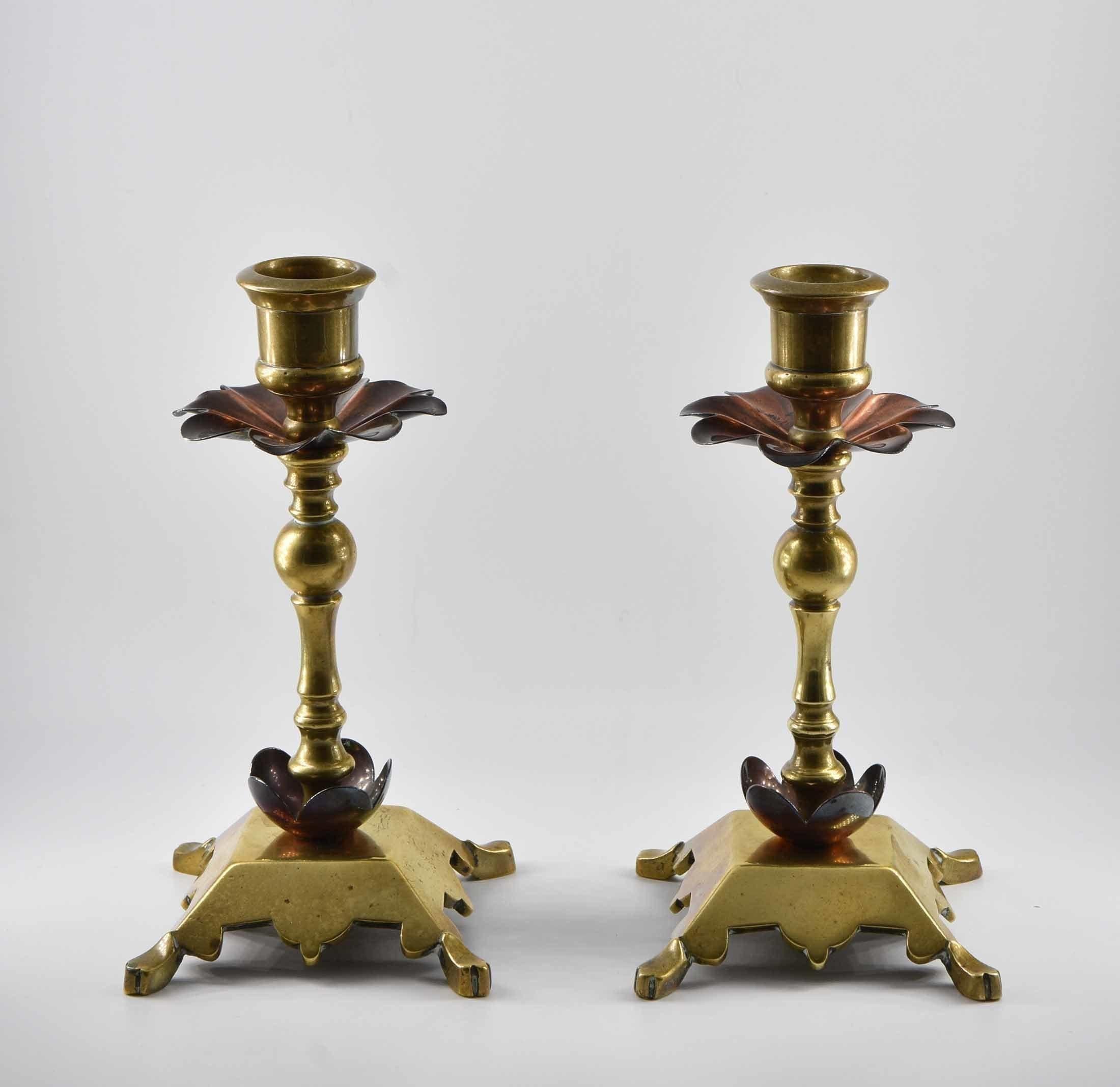 An Arts & Crafts pair of copper & brass candlesticks. Attributed to Benham & Froud. Stamped - Rd106185. Circa 1900.

The candlesticks have their original patina, there are a few knocks to one of the petals, please refer to the last photograph.