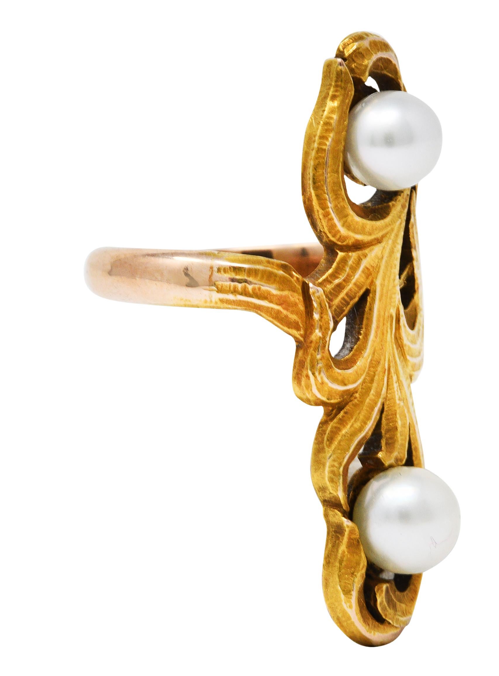 Full finger ring is designed as scrolling foliate

Whiplash style with a matte gold and subtly hammered finish

Featuring two button pearls measuring 5.0 and 5.5 mm

White and grayish in color with moderate rosè overtones and excellent