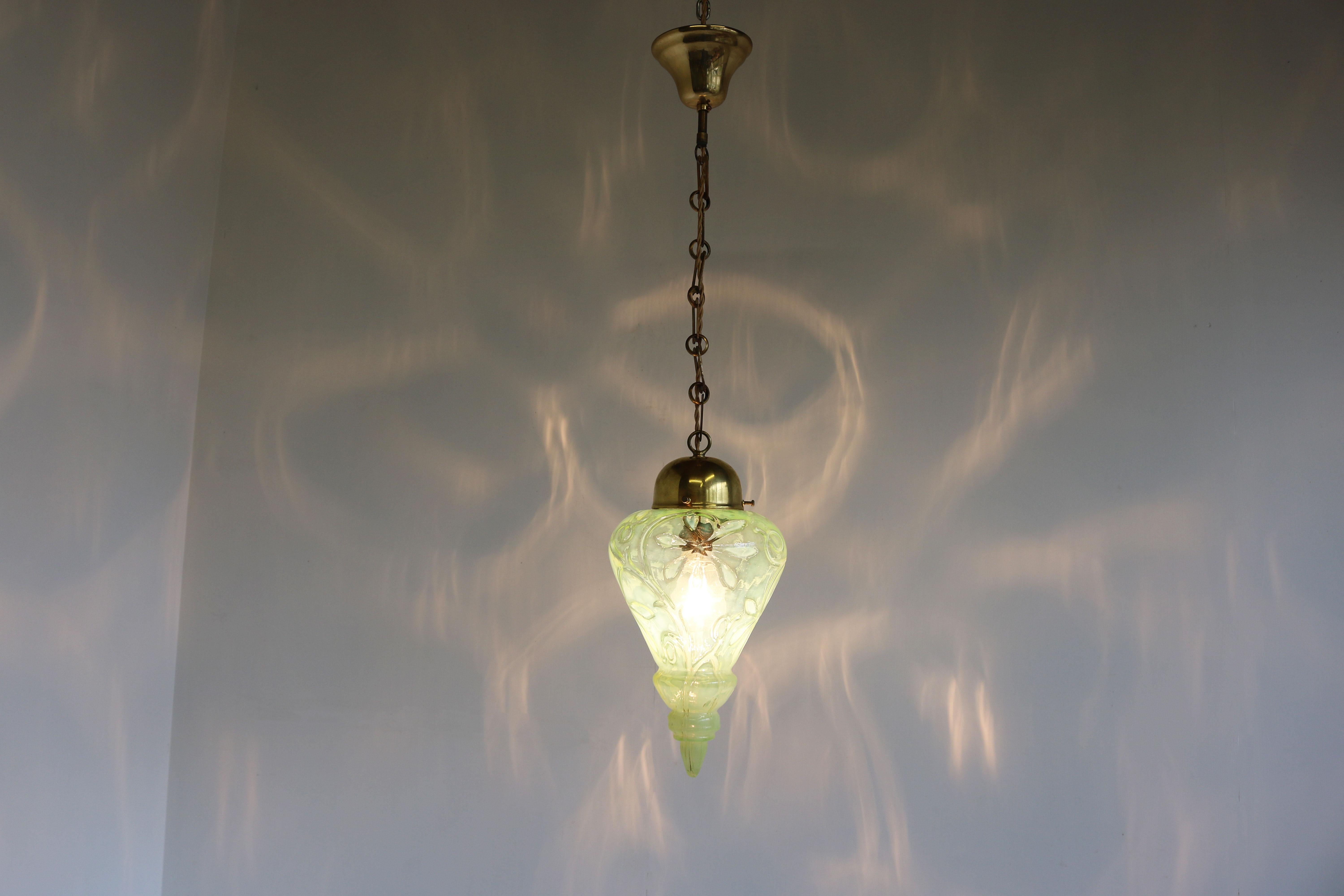 Rare Arts & Crafts brass hanging lamp with vaseline glass shade. Designed & produced by: Henry G. Richardson & Sons, England, circa 1900. 
Stunning hand blown glass shade in perfect condition, creates a stunning light effect when lit. 
The pendant