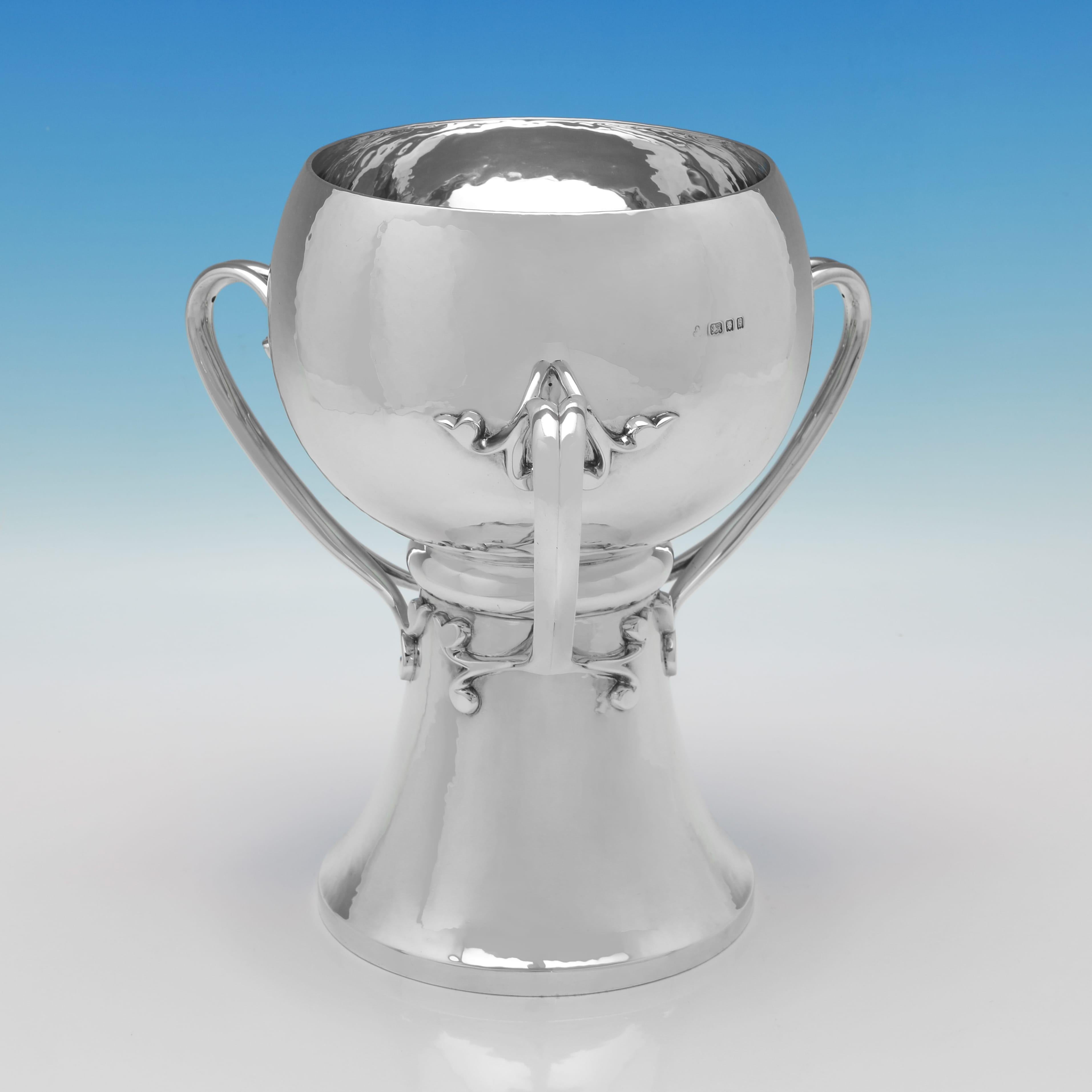 Poinçonnée à Londres en 1925 par Wakely & Wheeler, cette coupe ancienne en argent sterling est un bel exemple du style Arts & Crafts. Le design est sobre mais distinctif, avec une surface légèrement martelée et un subtil caractère forgé à la main.