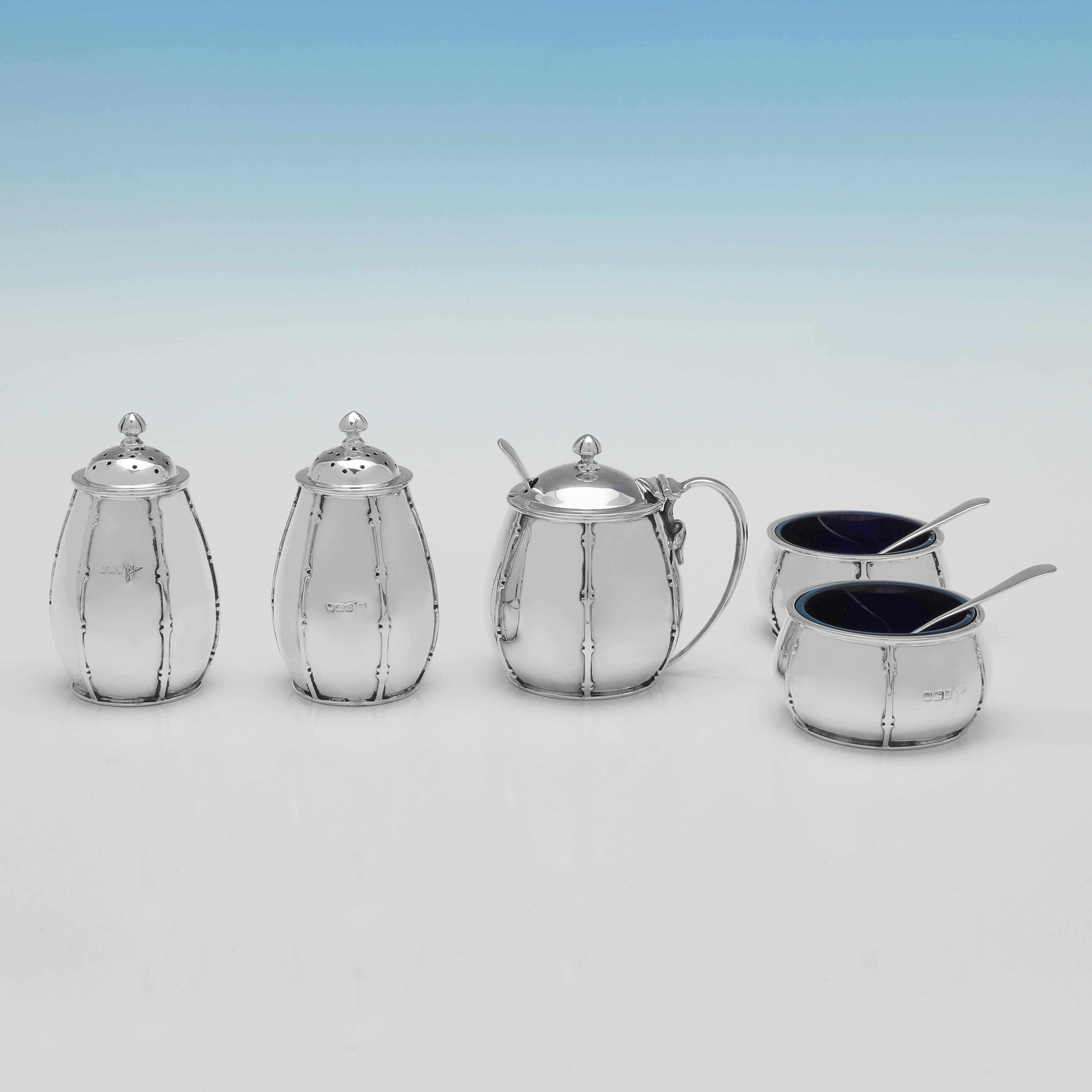 Hallmarked in Sheffield in 1913 by Walker & Hall, this stylish, 5 piece, Antique, Sterling Silver Condiment Set, is presented in its original box, and is in the Arts & Crafts taste. 

Each pepper pot measures 3.25