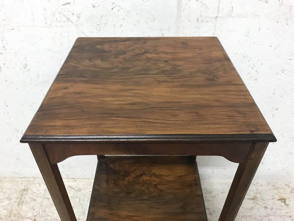 An Arts & Crafts petite rosewood two-tier side table with molded edges and shaped aprons beneath both shelves and molded edge details to the legs.