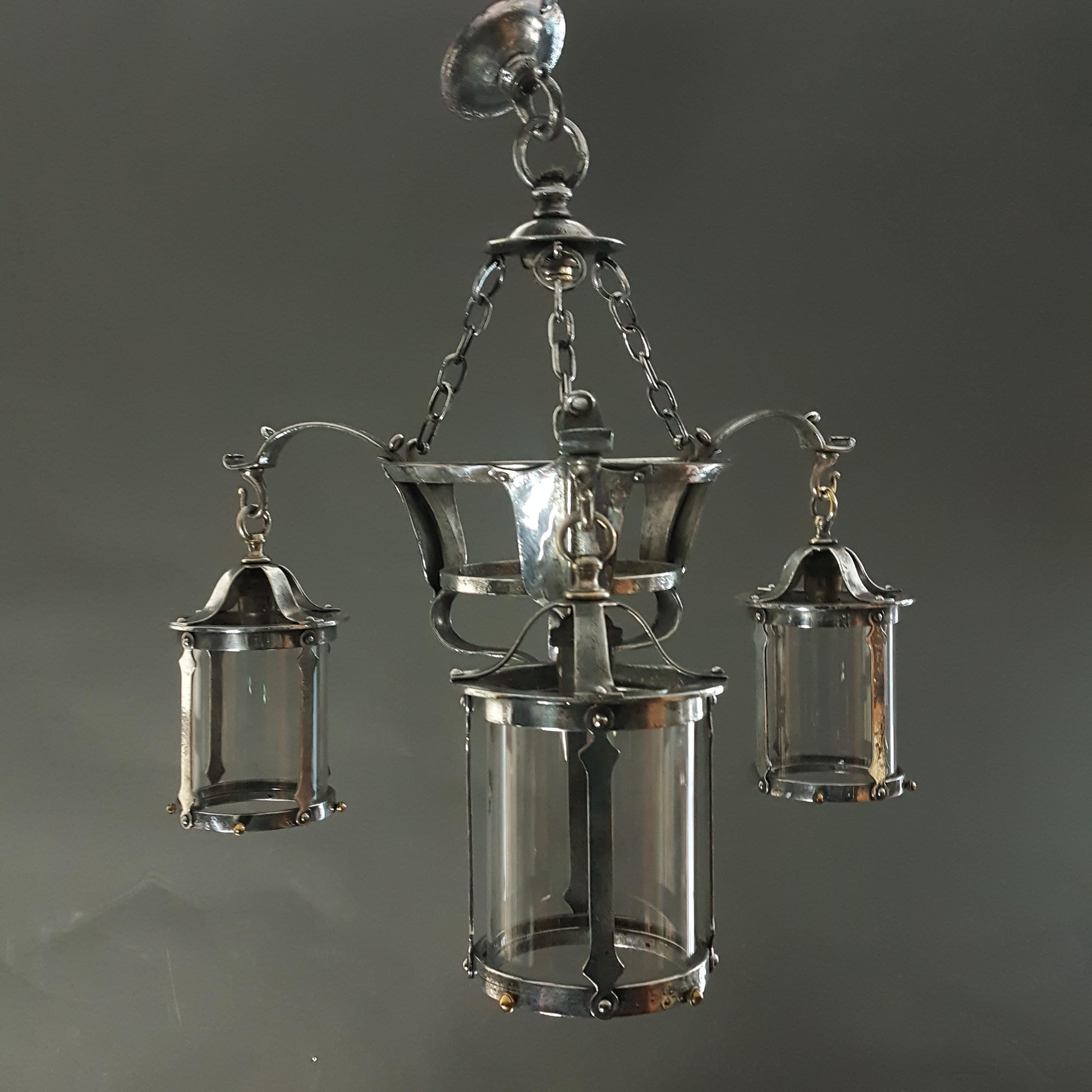 Lampadario o elecrolier in acciaio lucido originale del Movimento Arts & Crafts risalente al 1900-1910 circa.  Il lampadario è in buone condizioni, i paralumi in vetro sono stati sostituiti.  e  Attualmente non è cablata, ma il cablaggio secondo le