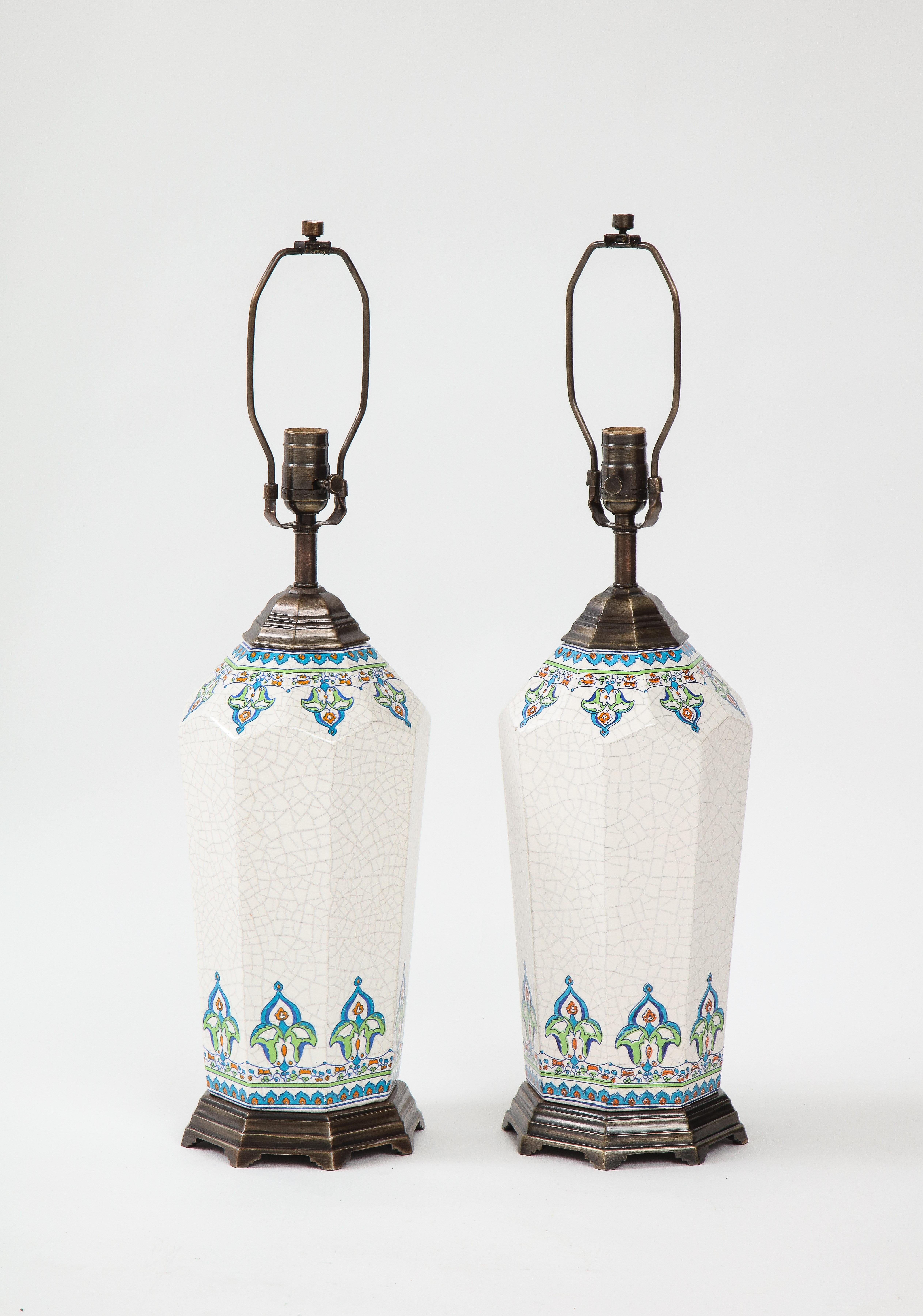 Pair of crackled glaze porcelain lamps featuring an Arts & Crafts transfer border. Lamps have bronze bases and hardware throughout. Rewired for use in the USA, 100W max.