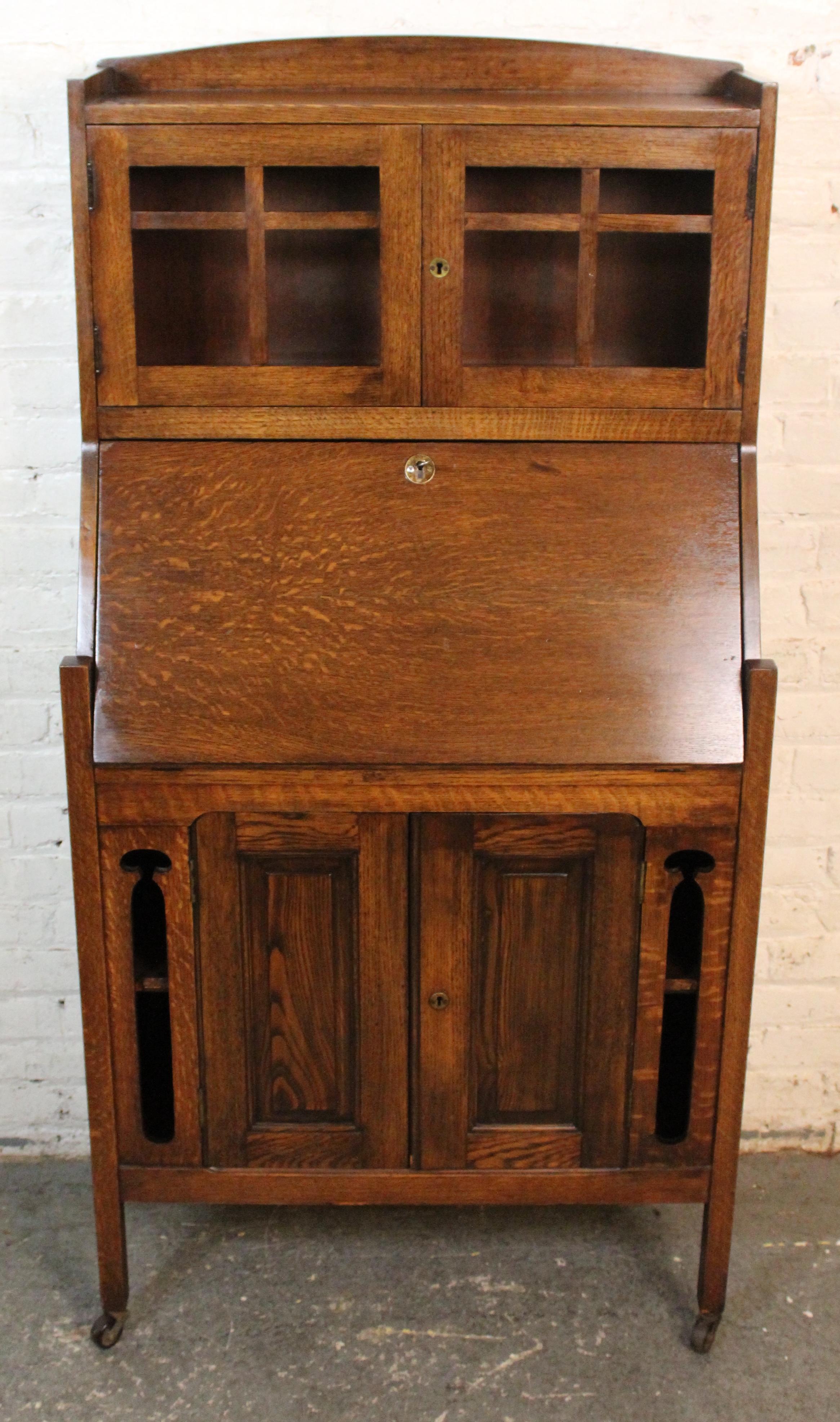 Una scrivania Arts & Crafts splendidamente realizzata in quercia quartersawn riccamente scolpita, che mette in evidenza l'enfasi del movimento sui materiali onesti e sulla maestria artigianale. Le caratteristiche includono una superficie di