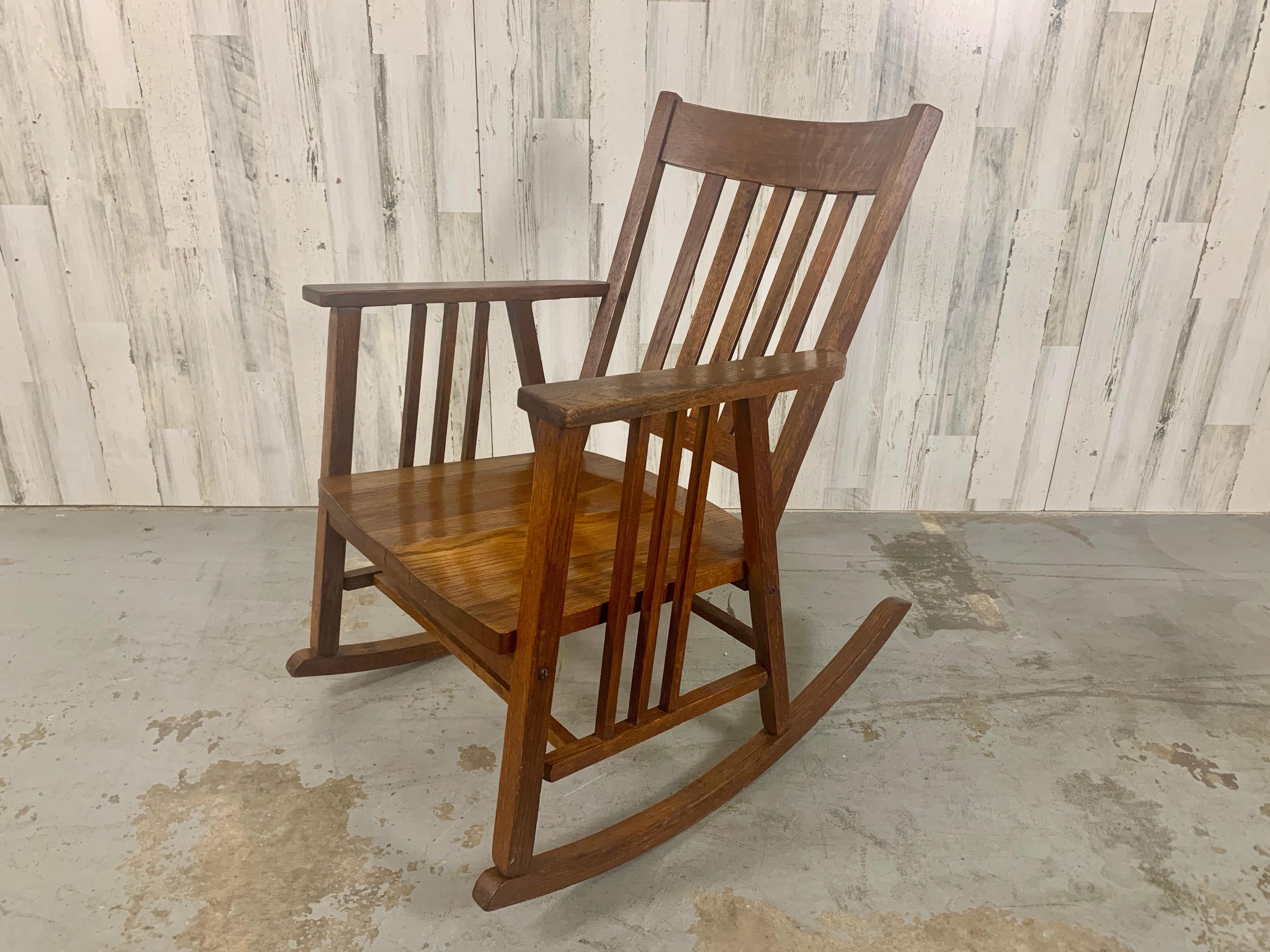 Beautiful Arts & Crafts rocking chair with slight modern feel with the side arm supports extending below the chair seat. Made by Cleveland Chair Company 