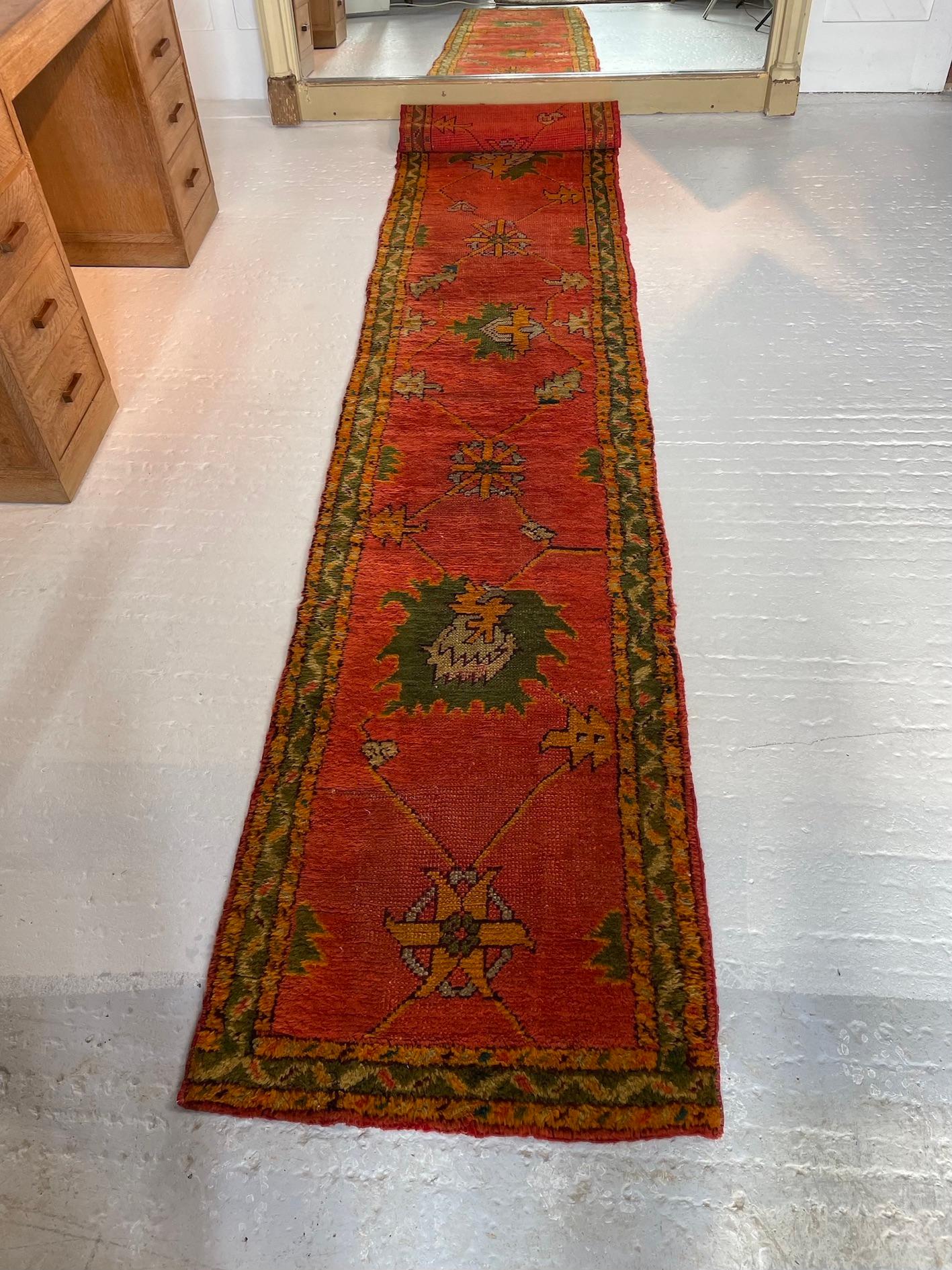 An original Arts & Crafts runner with red field depicting a stylised multi-colour floral design
Donegal weave designed by Gavin Morton
circa 1900

Donegal Carpets was founded in 1898 by the Scottish textile manufacturer Alexander Morton. He had
