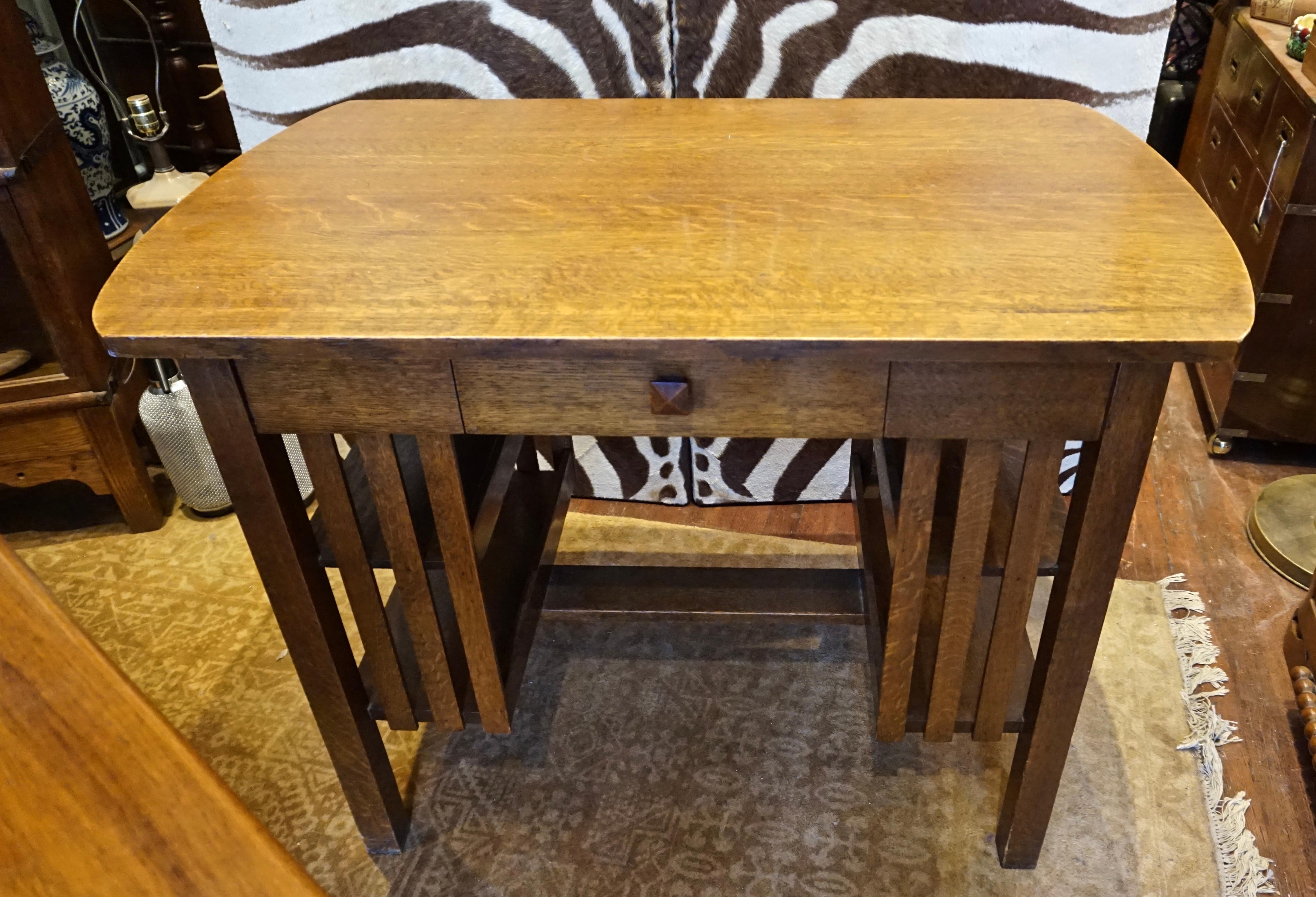 Compact mission Arts & Crafts desk constructed from solid quarter sawn oak with excellent grain and original patina. Shelves on the sides and single drawer. Good sturdy condition, circa 1905-1910.

    