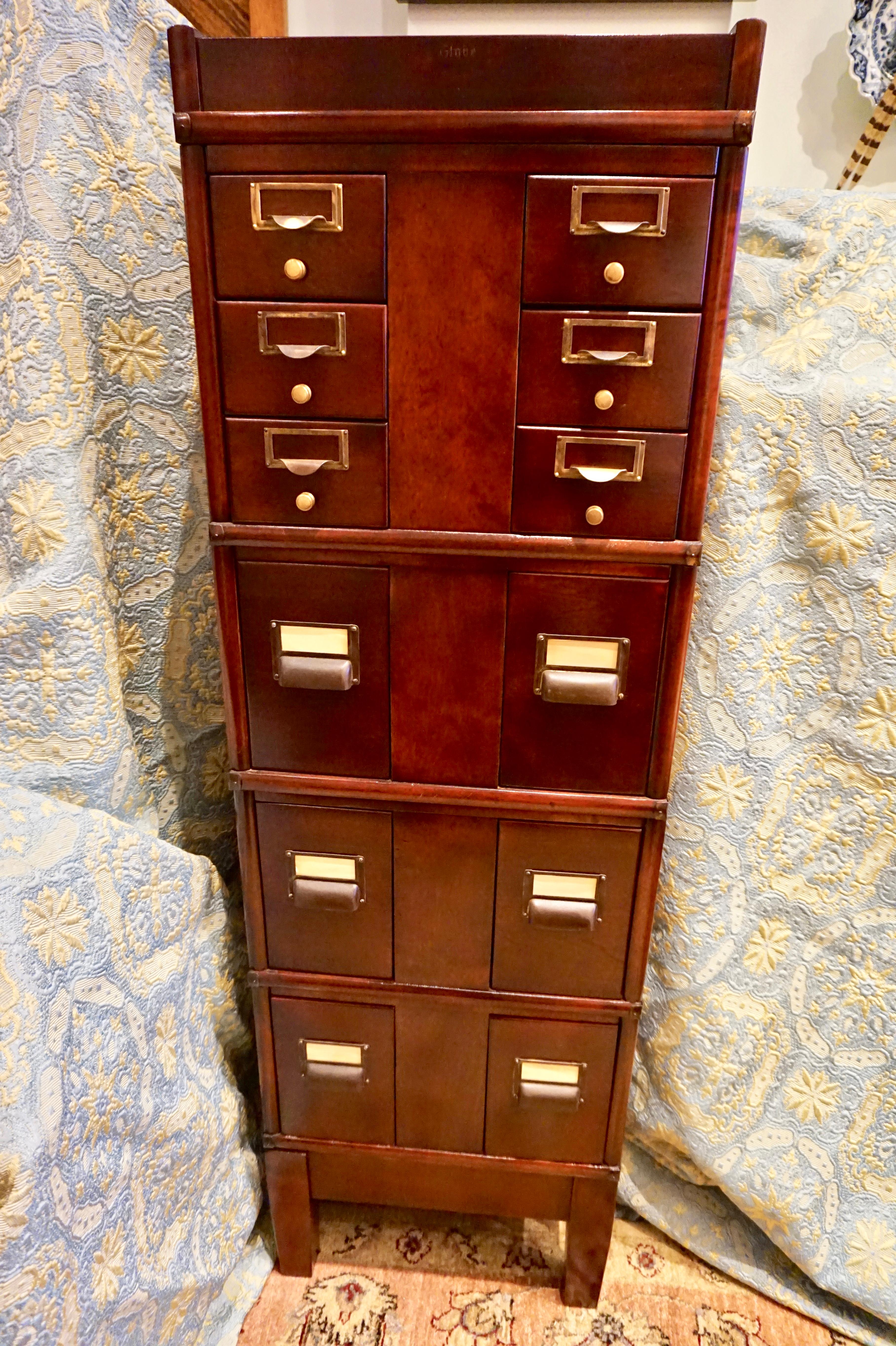 Exquisite solid Mahogany filing cabinet with brass hardware. Stacking mechanism for ease of movement with paneling on the sides and brass knobs. Stamped and sits on a raised stand. Practical with much Arts & Crafts elegance and charm. A true