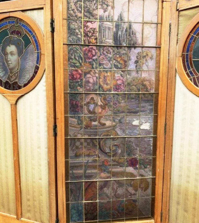 Antique French stained glass and silk 5 panel screen. Four panels feature stained glass cameos of noble men and women, tallest centre panel features a landscape scene in stained glass. Each panel is framed by walnut wood and feet have brass