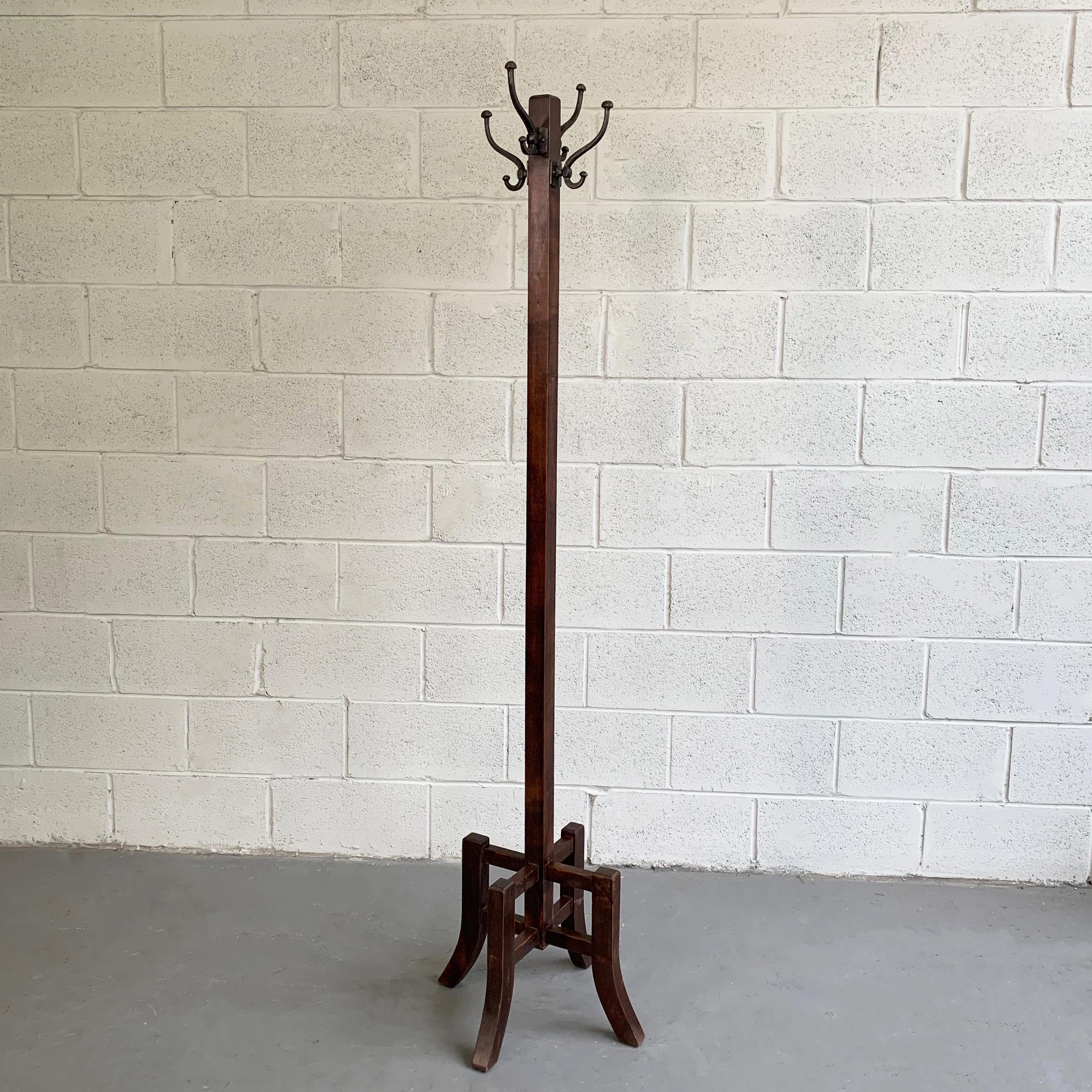 Early 20th century, Arts & Crafts, standing coat rack features a stained maple Stand with decorative base and 4 cast iron double hooks.