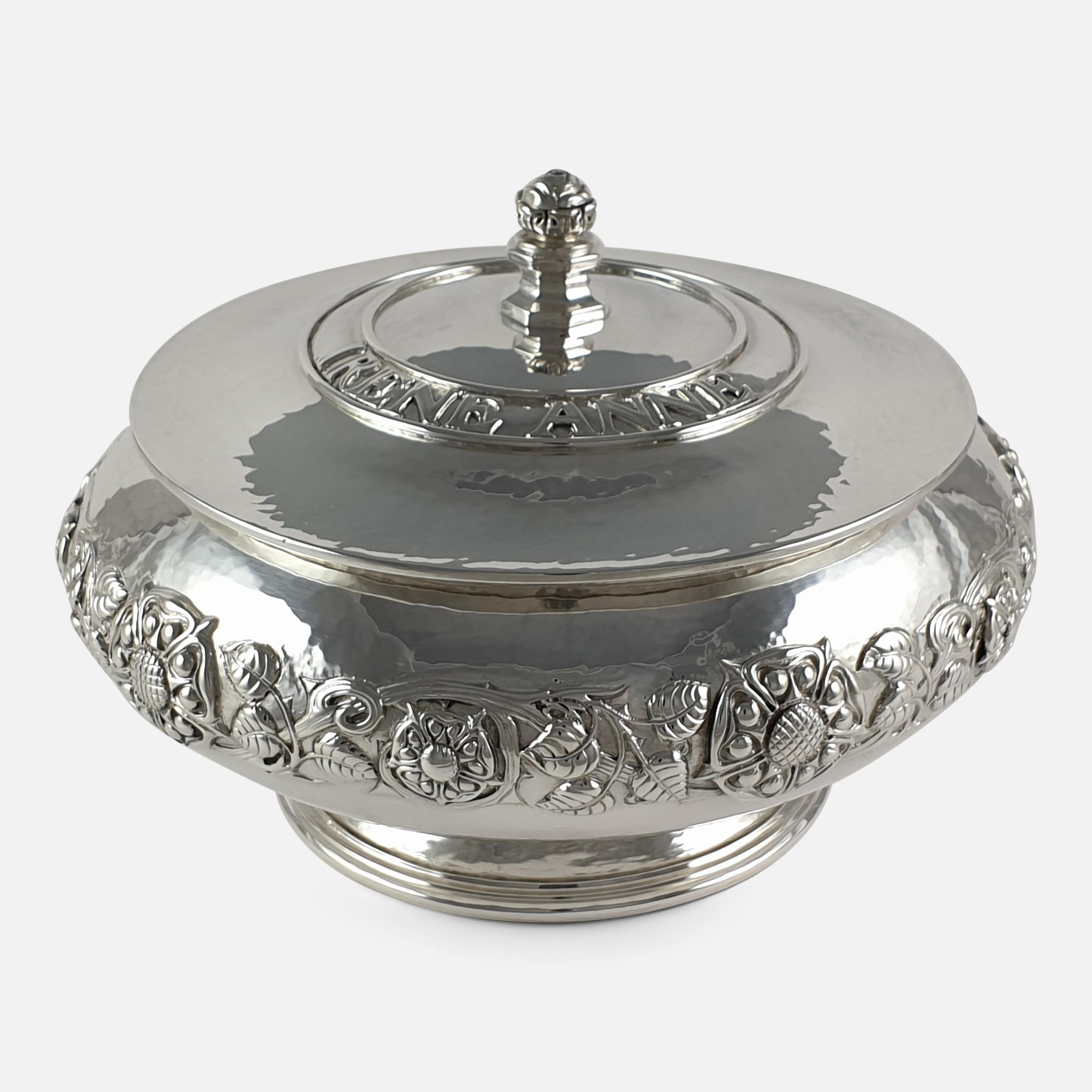 An Arts & Crafts style sterling silver bowl with cover made by Omar Ramsden. The cover is set with a rose finial and the applied inscription 