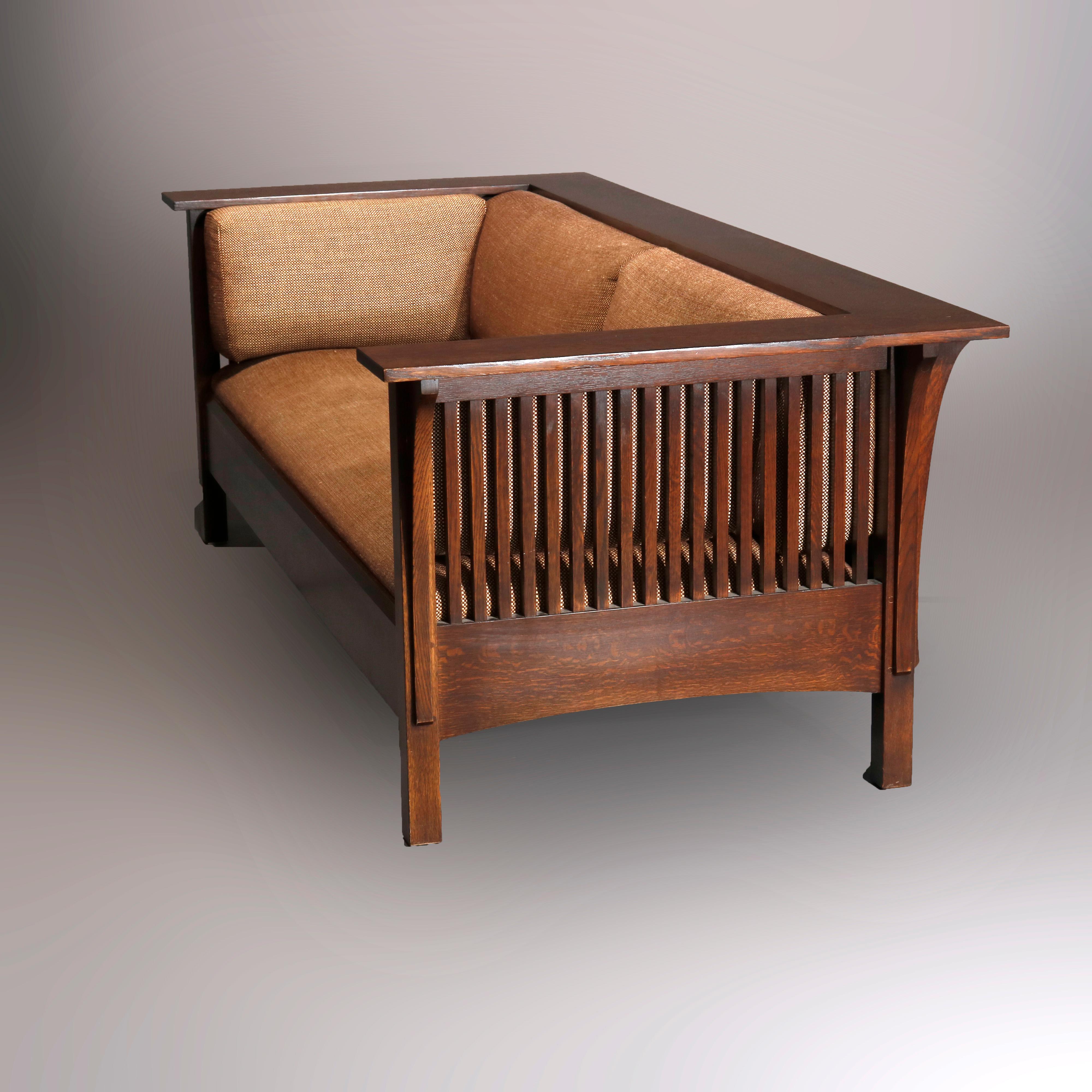 An antique Arts and Crafts Prairie School settle by Stickley offers oak construction with even arm design having spindles and upholstered cushions, original maker label as photographed, 20th century

Measures- 29.75