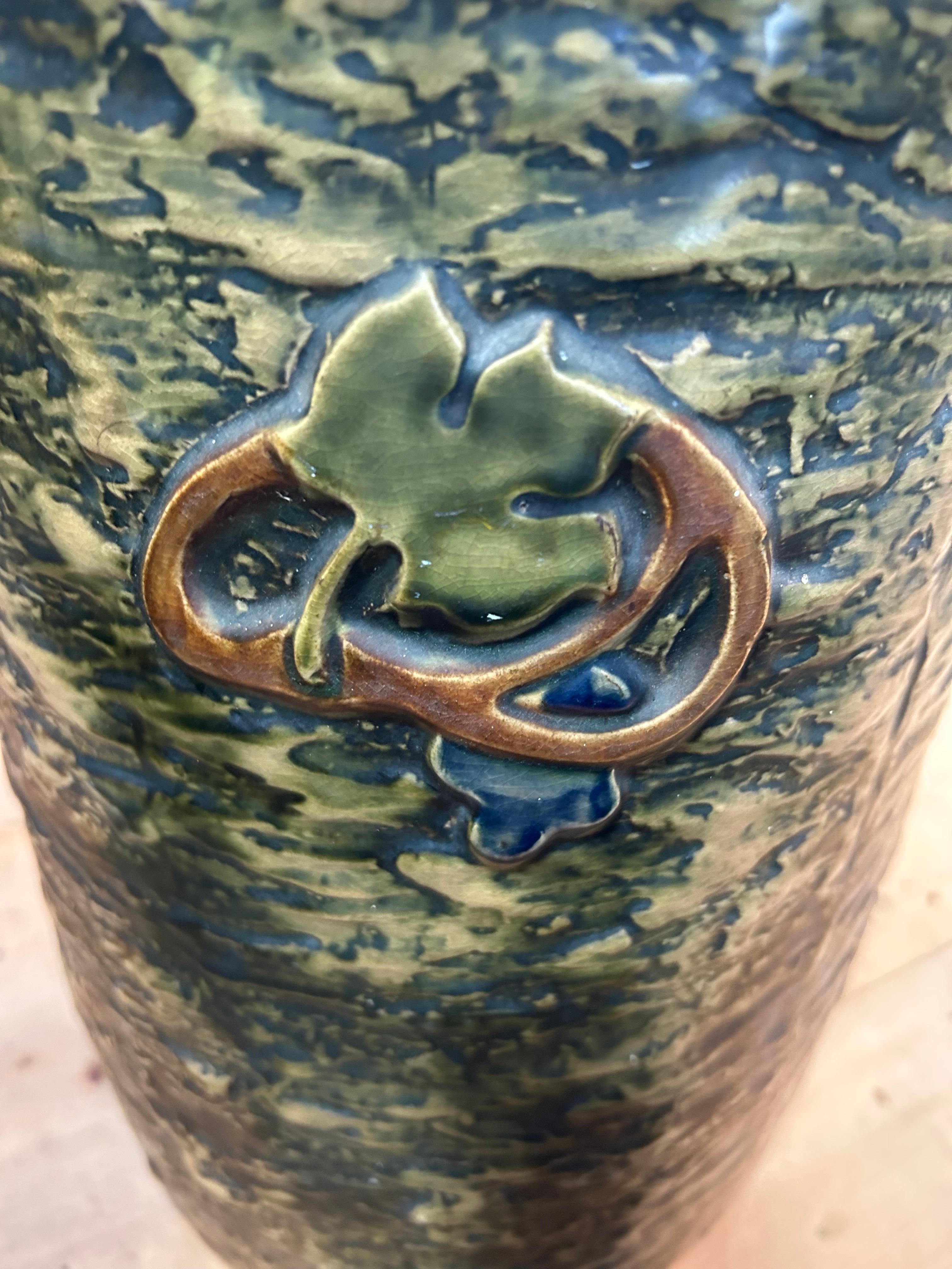 Beautiful textured and glazed ceramic umbrella stand in the Arts & Crafts style having earth colors and oak leaf decoration.