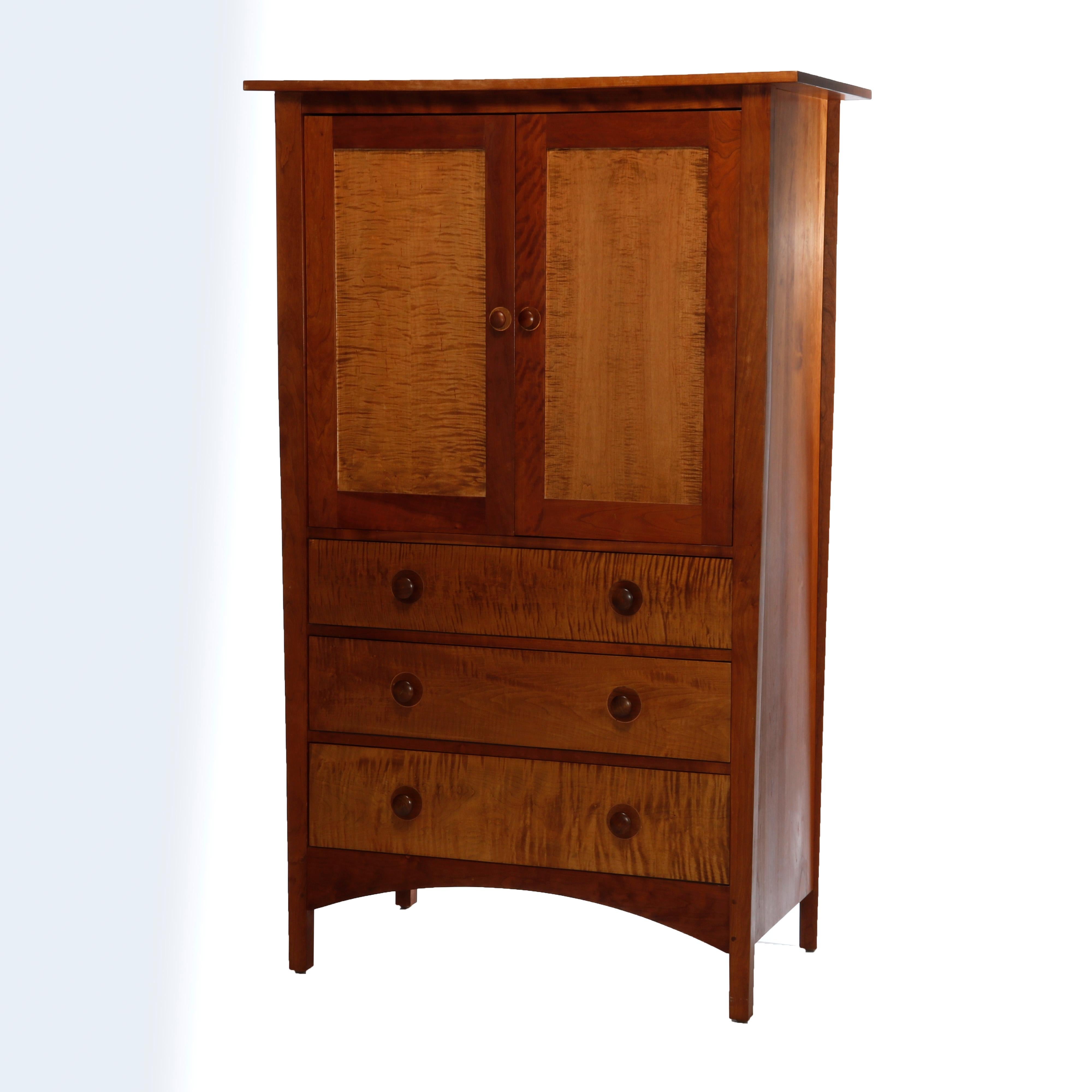 An Arts & Crafts style Harvey Ellis Design armoire entertainment center by Stickley offers birdseye maple construction with upper cabinet surmounting three long drawers, maker mark as photographed, 20th century

Measures - 68.5'' H x 42.5'' W x