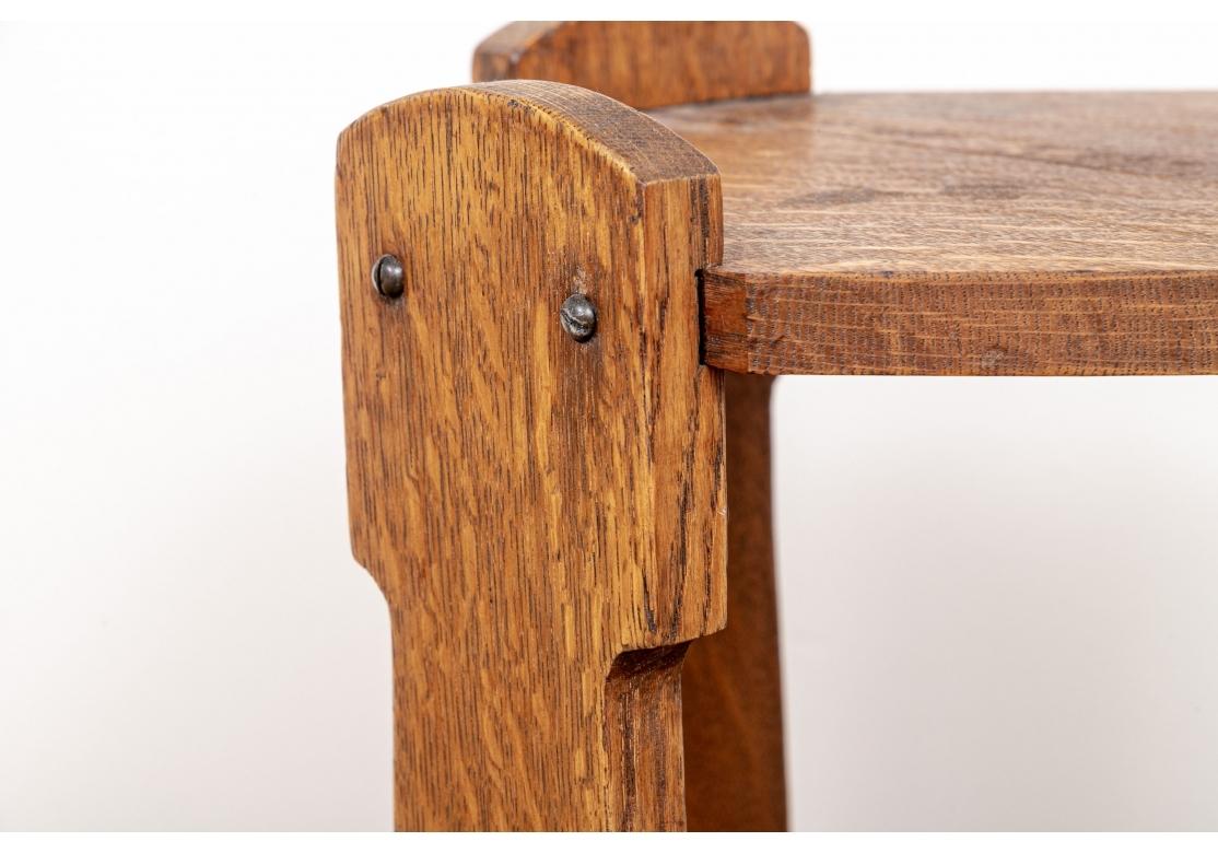 Eichenweintisch aus der Zeit des Arts & Crafts mit freiliegender Schraubenkonstruktion. Die geformten Beine sind eingekerbt, um die runde Platte aufzunehmen und werden von einer X-förmigen Bahre getragen.
Abmessungen: 12 3/4