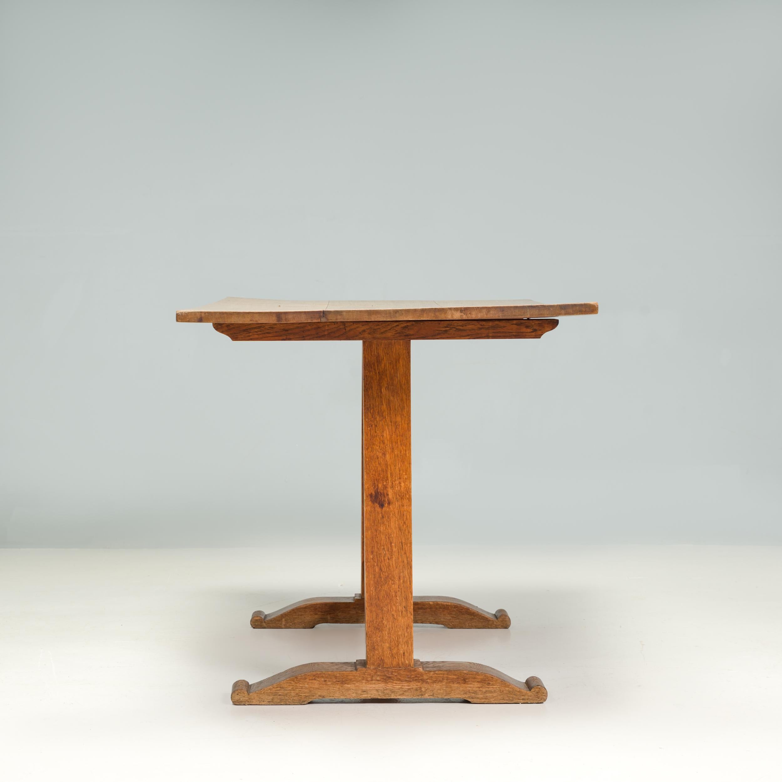 A beautifully constructed wooden refectory table in the Arts & Crafts style.

The table has a traditional aesthetic, with a wonderfully worn down rectangular table top made up of several planks of wood.

The plinth style legs have carved feet and a
