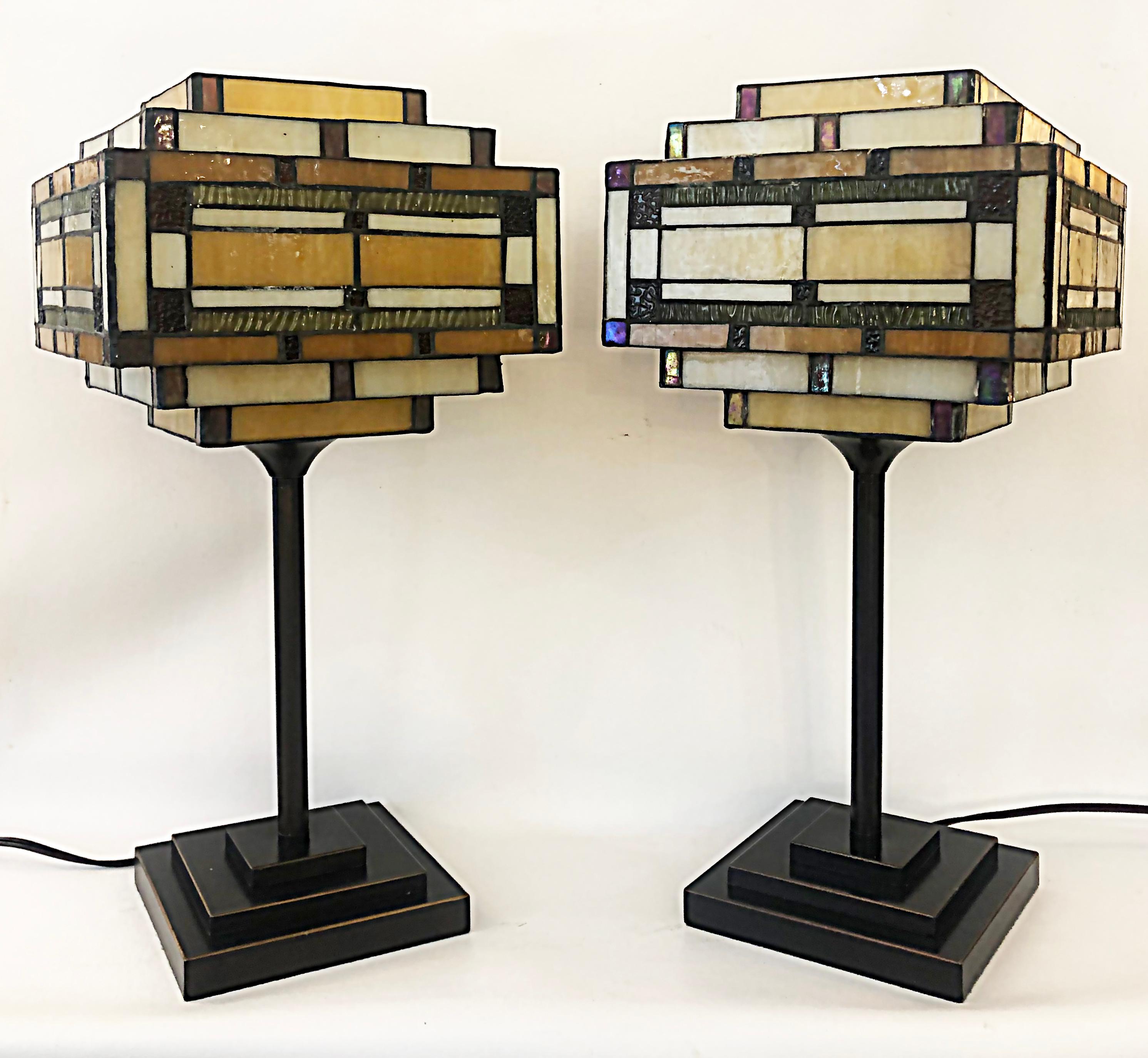 Arts & Crafts Style table lamps with stained glass shades, patinated metal bases

Offered for sale is a pair of modern Arts & Crafts style table lamps with stained glass shades. The lamps have a Frank Lloyd Wright influence with both the glass and