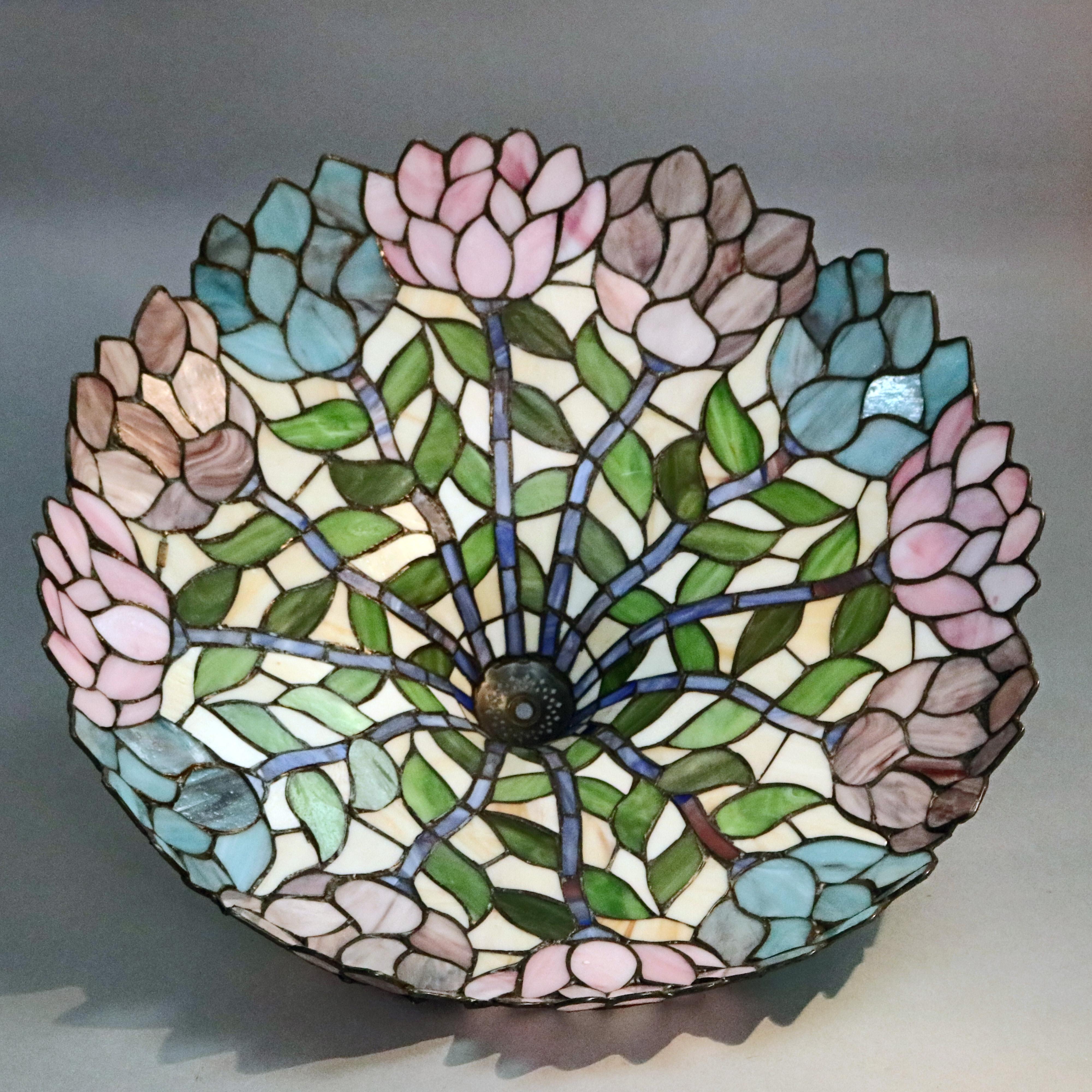 An Arts & Crafts Tiffany School table lamp offers parasol form shade with leaded slag glass floral mosaic raised on double socket foliate cast base, elements of Art Nouveau, 20th century

***DELIVERY NOTICE – Due to COVID-19 we are employing