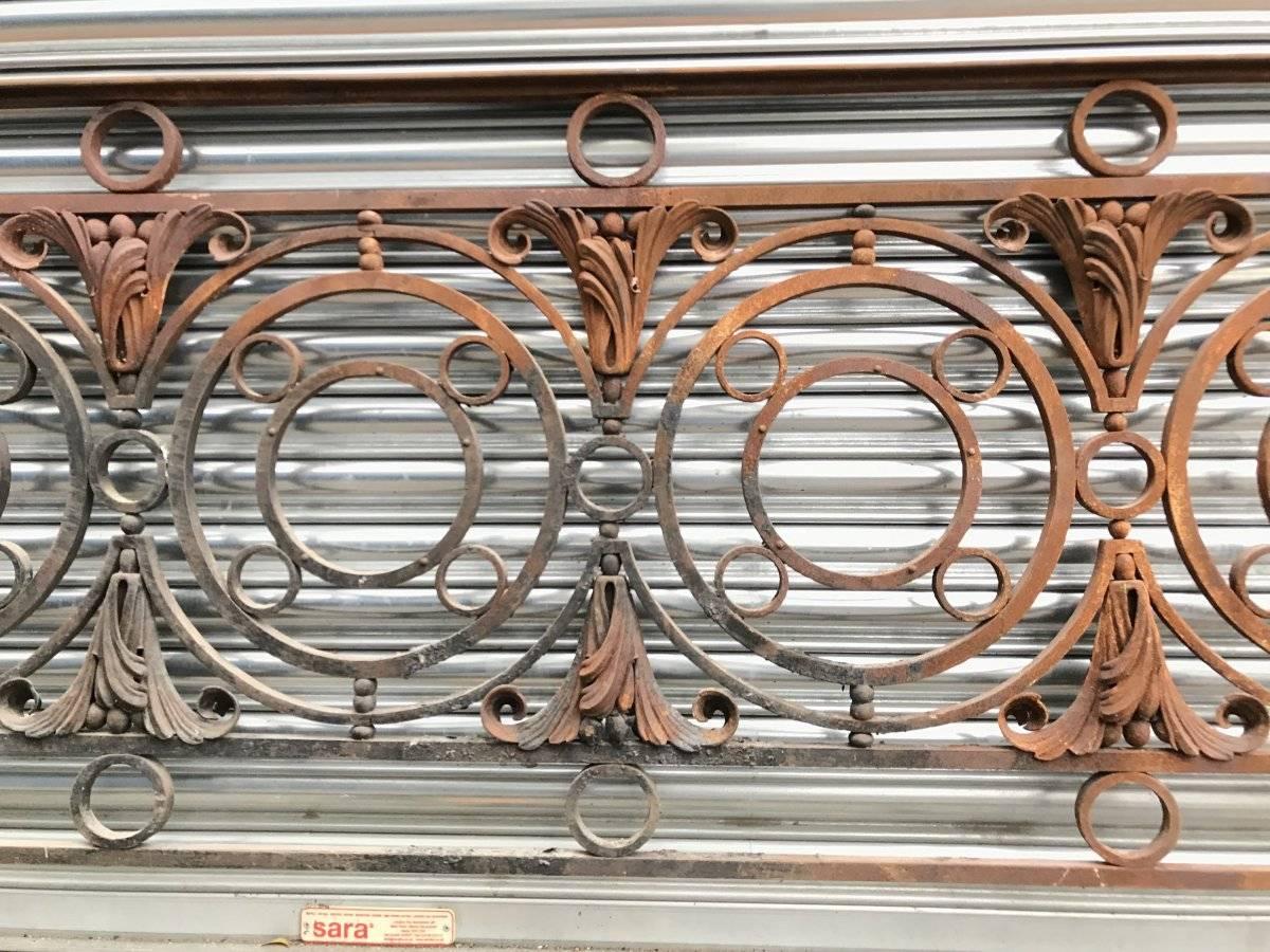 An Arts & Crafts style late Victorian decorative cast and wrought iron railing or balcony banister rail with circular and small ball details and stylized floral leaf details with a nicely shaped hand rail to the top.
Measures: Length 122 inches,