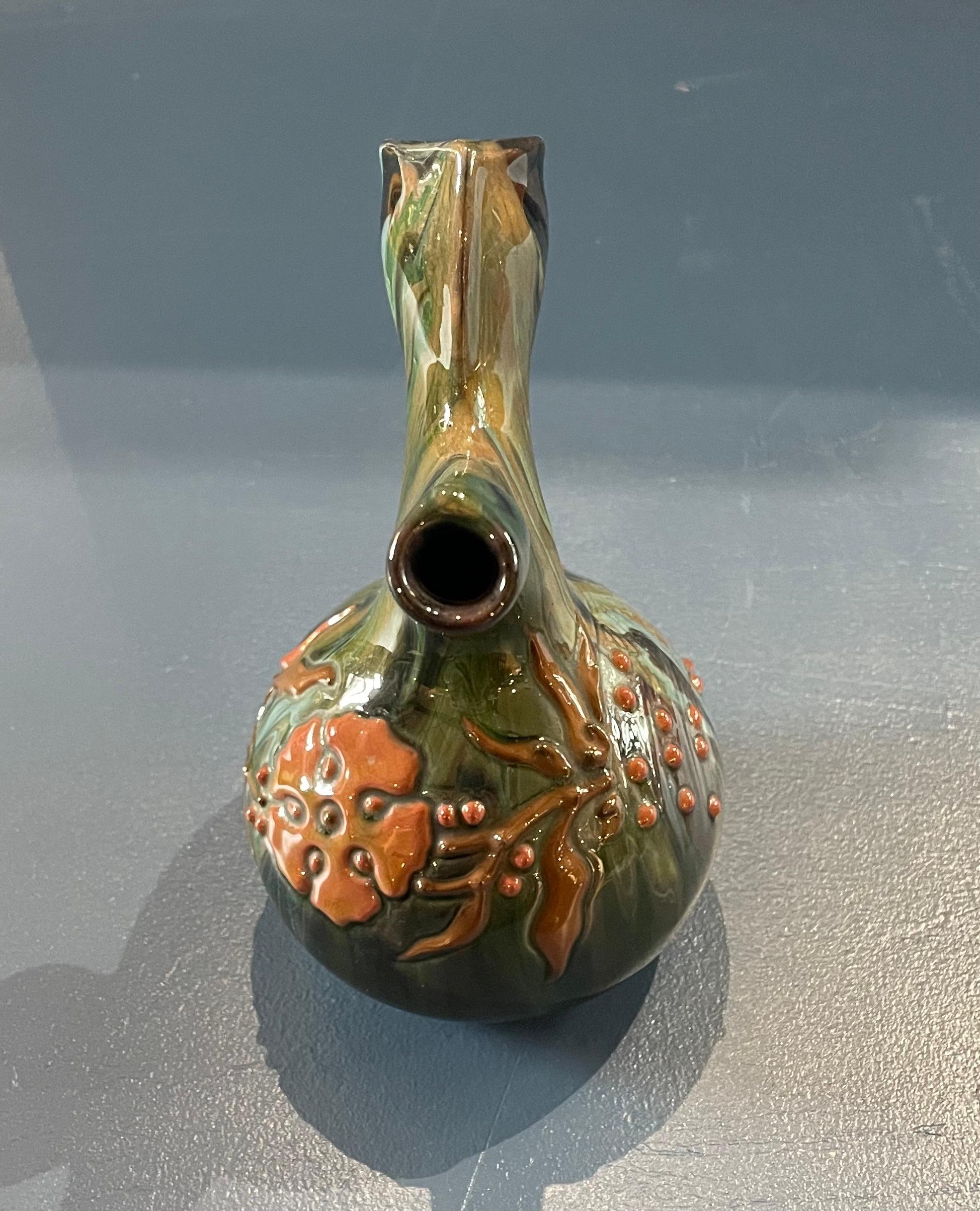 Arts & Crafts pottery pouring jug with stylised floral design

Lead glazed earthenware with raised slip decoration

Elton Sunflower Pottery

Elton painted mark 

Circa 1910