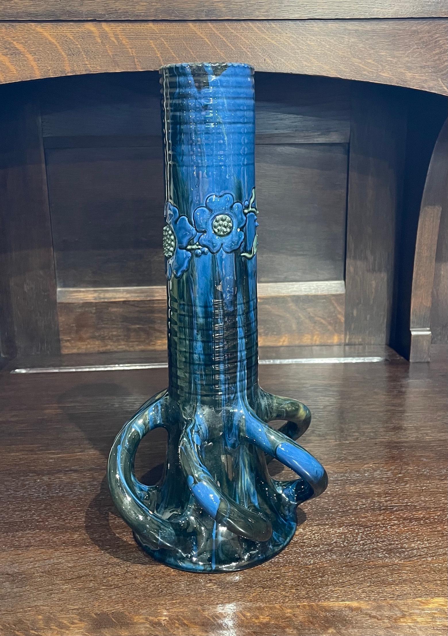 Arts & Crafts large pottery vase with stylised floral design

 Unusual twisted looped bottom 

Lead glazed earthenware with raised slip decoration 

Elton Sunflower Pottery

Elton painted mark

Circa 1910

Height 35cm. Diameter 17cm