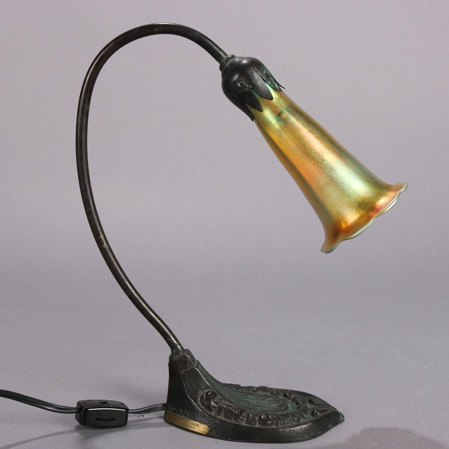 Antique Arts & Crafts lily lamp by Tiffany Studios features cast bronze floral lily form base with L.C.T. (Louis Comfort Tiffany) signed Favrile art glass shade, original Tiffany Studios label, professionally rewired, circa 1910

Measures: 11