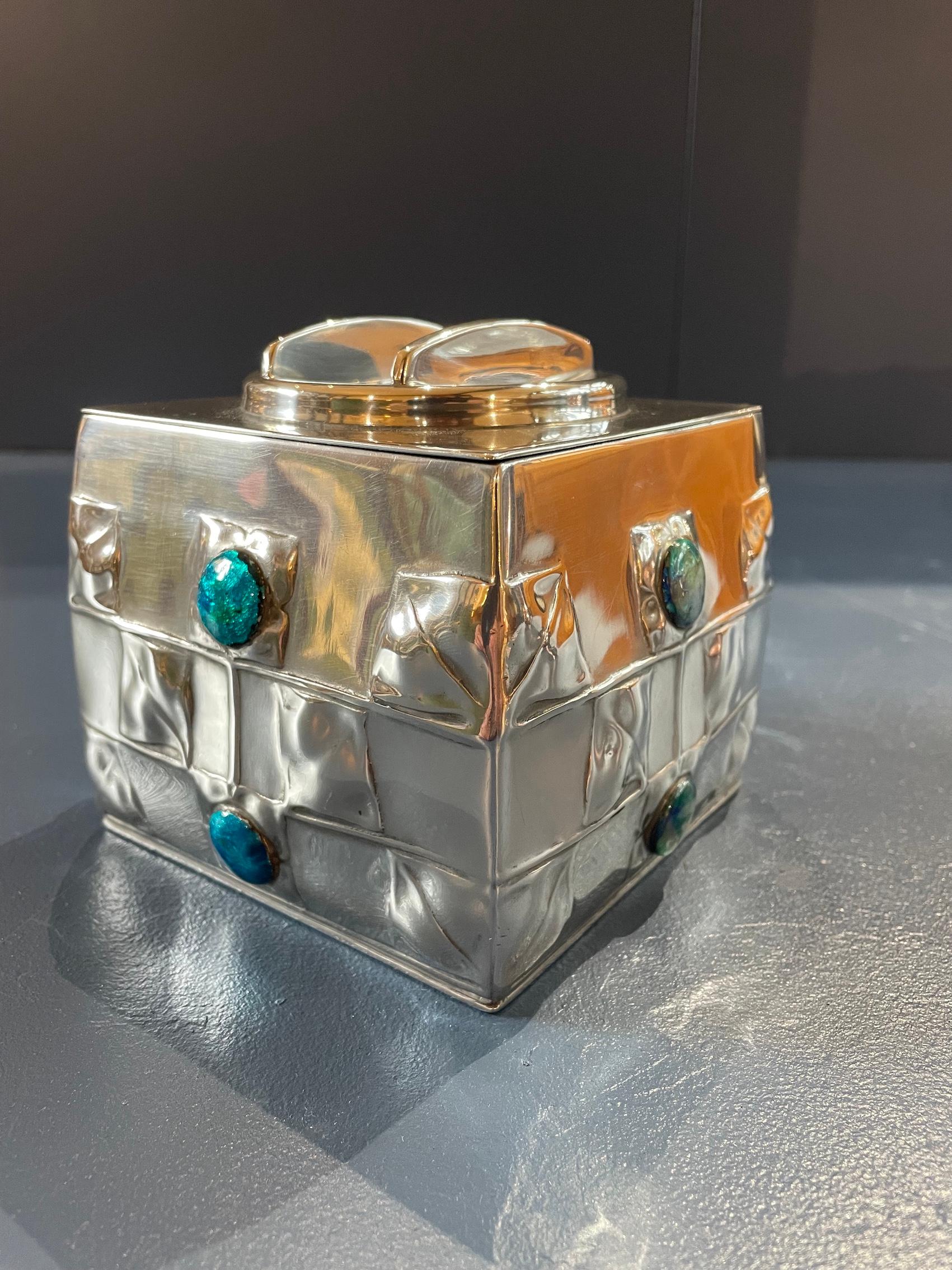 Arts & Crafts ‘Tudric’ pewter biscuit box 

with enamel decoration and original lid

Designed by Archibald Knox

For Liberty & Co

Model No 0194

Circa 1900

Height 12cm Width 12cm. Depth 12cm