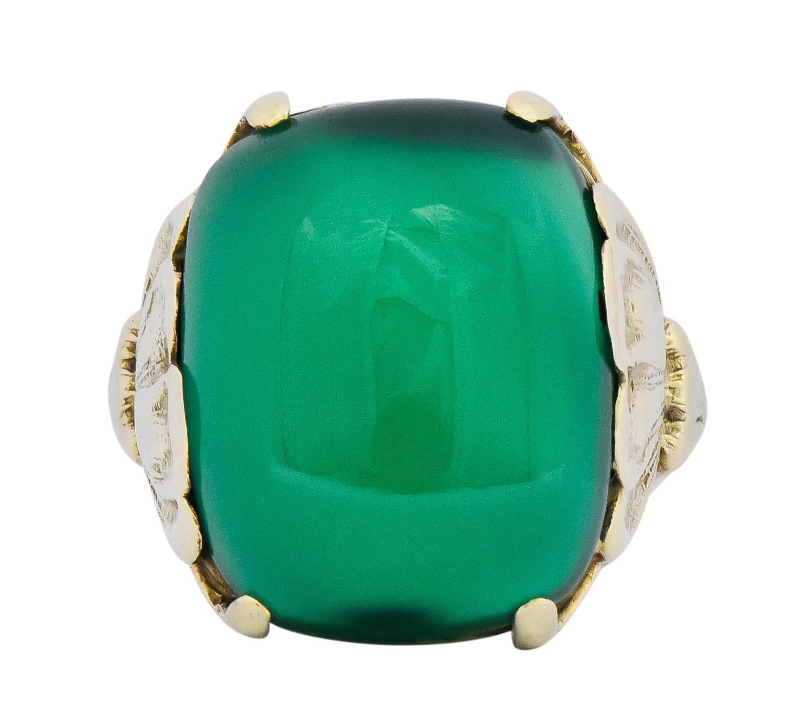 Centering a cushion cabochon chrysoprase measuring 16.0 x 12.0 mm, translucent and a lush medium dark green

Flanked by gold prongs extending from stylized lotus motif on shoulders

With a ribbed shank stamped 14k for 14 karat gold

Ring Size: 4 1/4